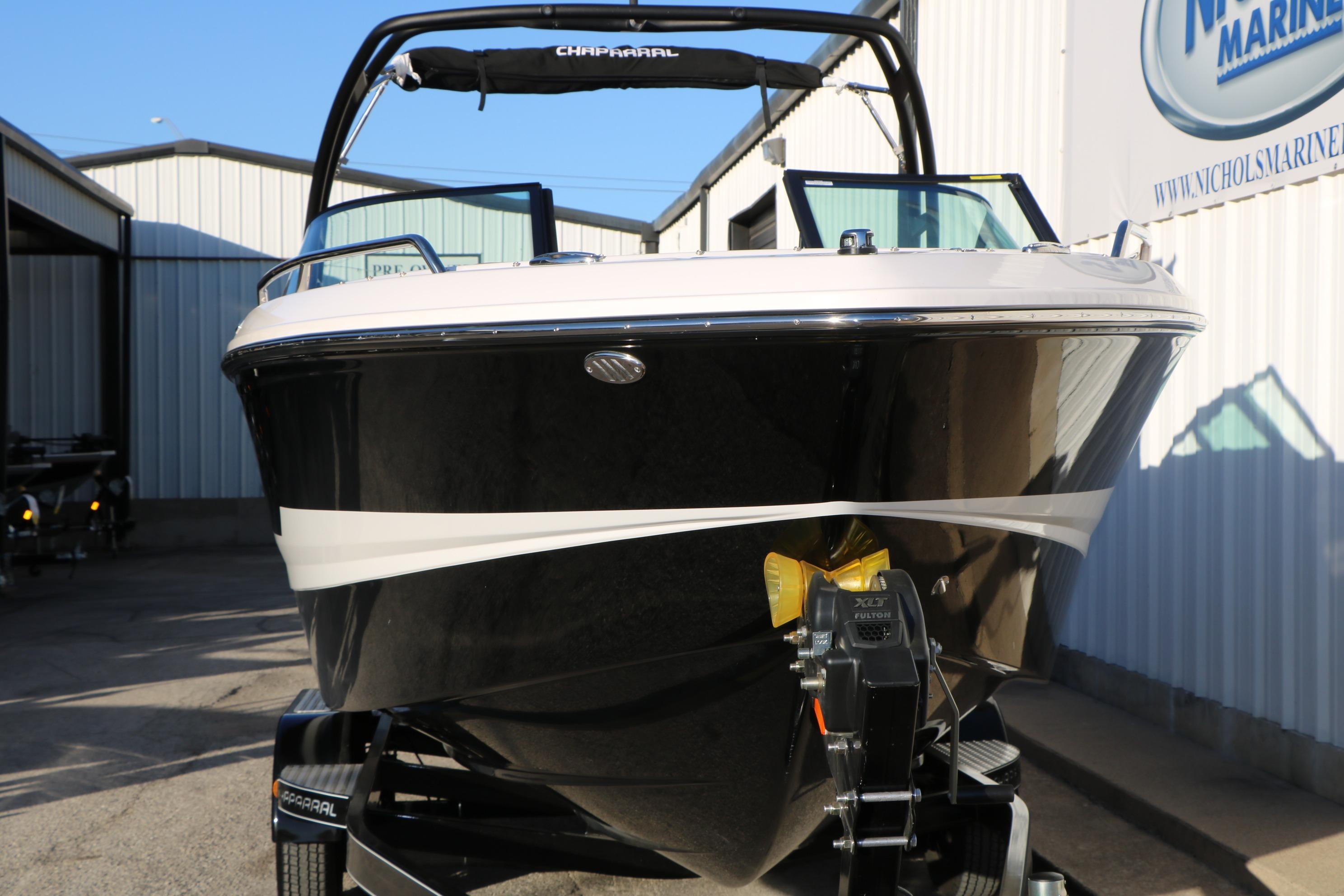 2026 Chaparral 247 SSX boat on trailer, black and white exterior, parked outdoors.