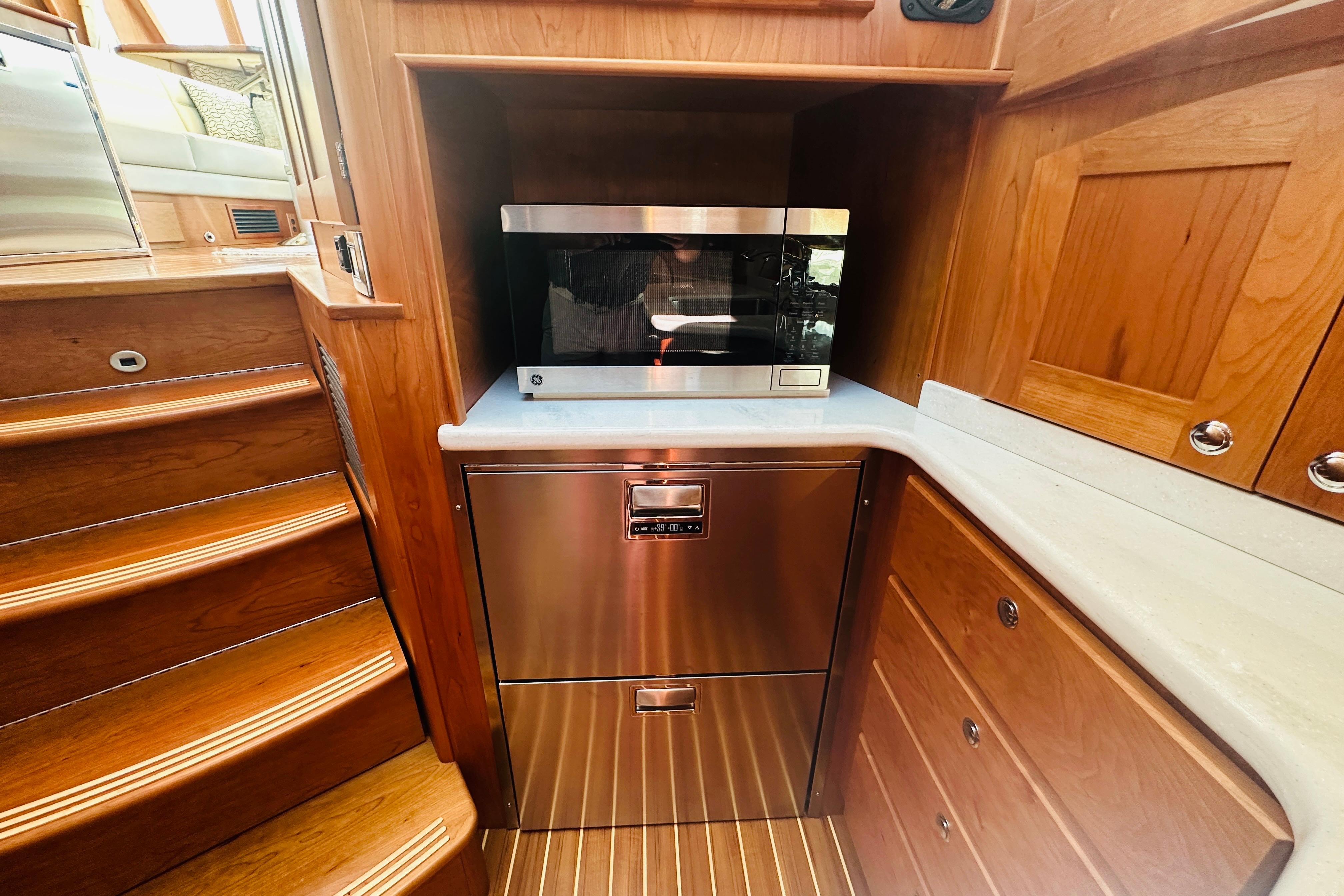 Modern kitchen area in 2025 Sabre 48 Salon Express yacht with microwave and wooden cabinetry.