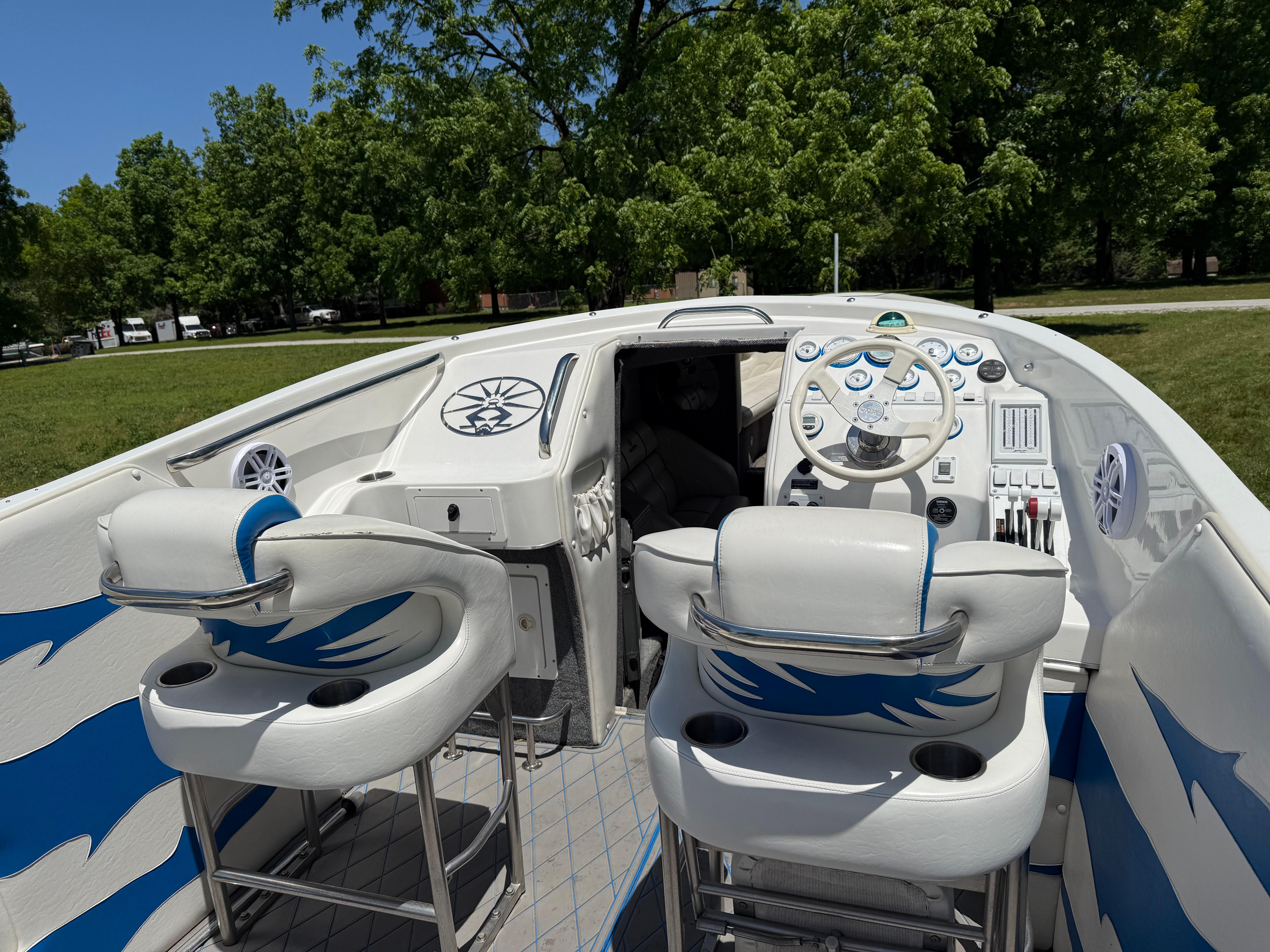 2005 Kachina Bolero boat interior with white and blue seating, steering wheel, and control panel.