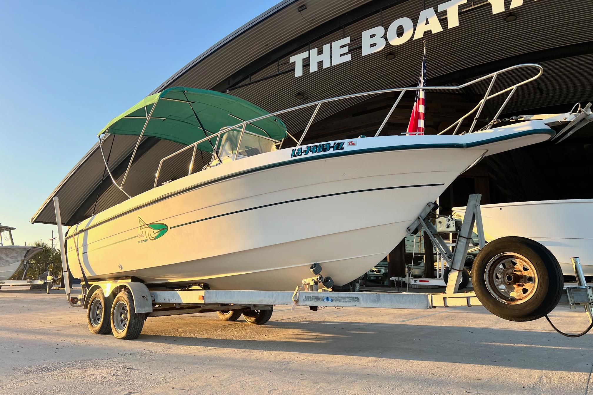 1998 Sunbird 230 CC boat on trailer, parked outside a boat yard.