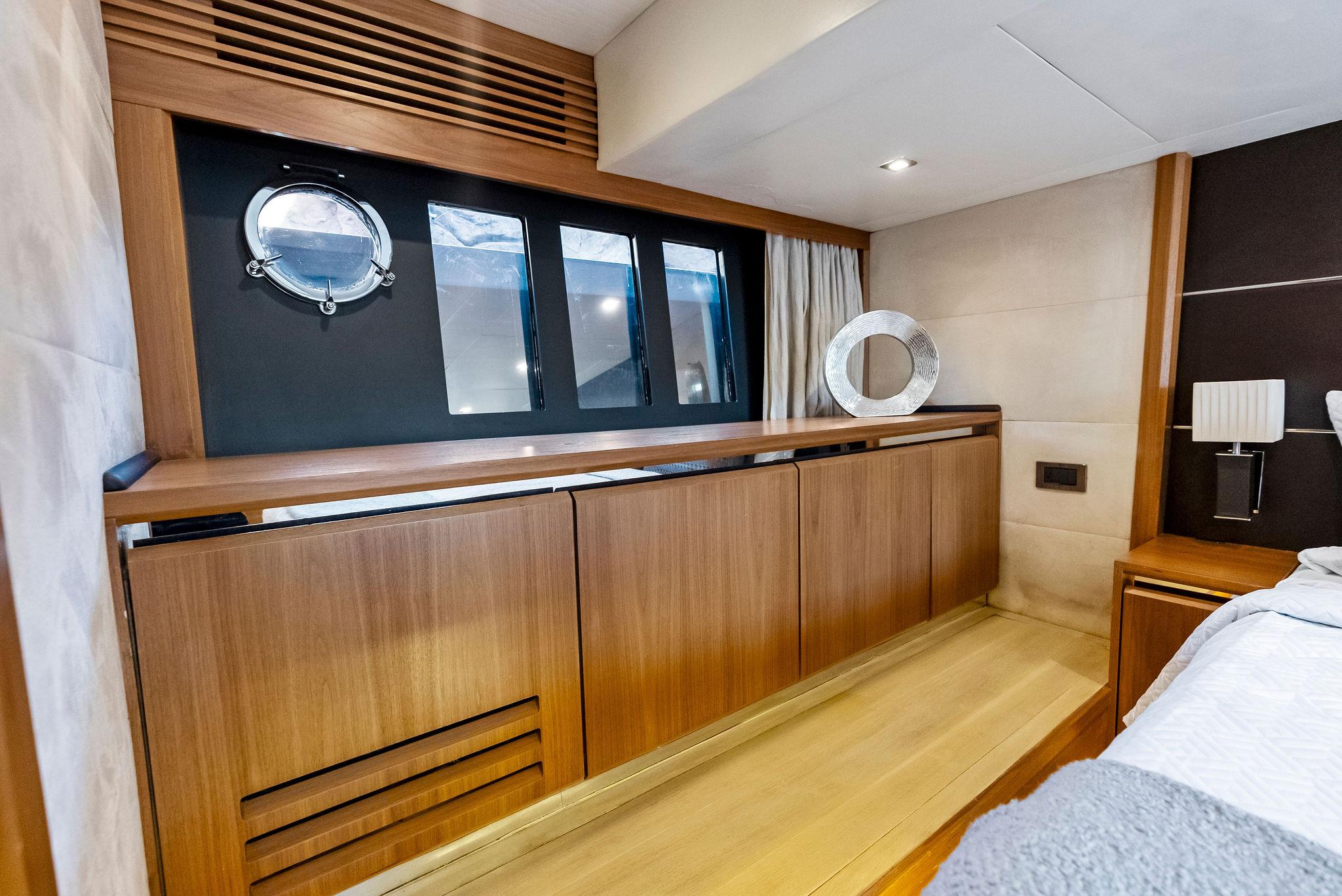 Luxurious interior of 2013 Absolute 55 FLY yacht with wooden cabinetry and porthole window.