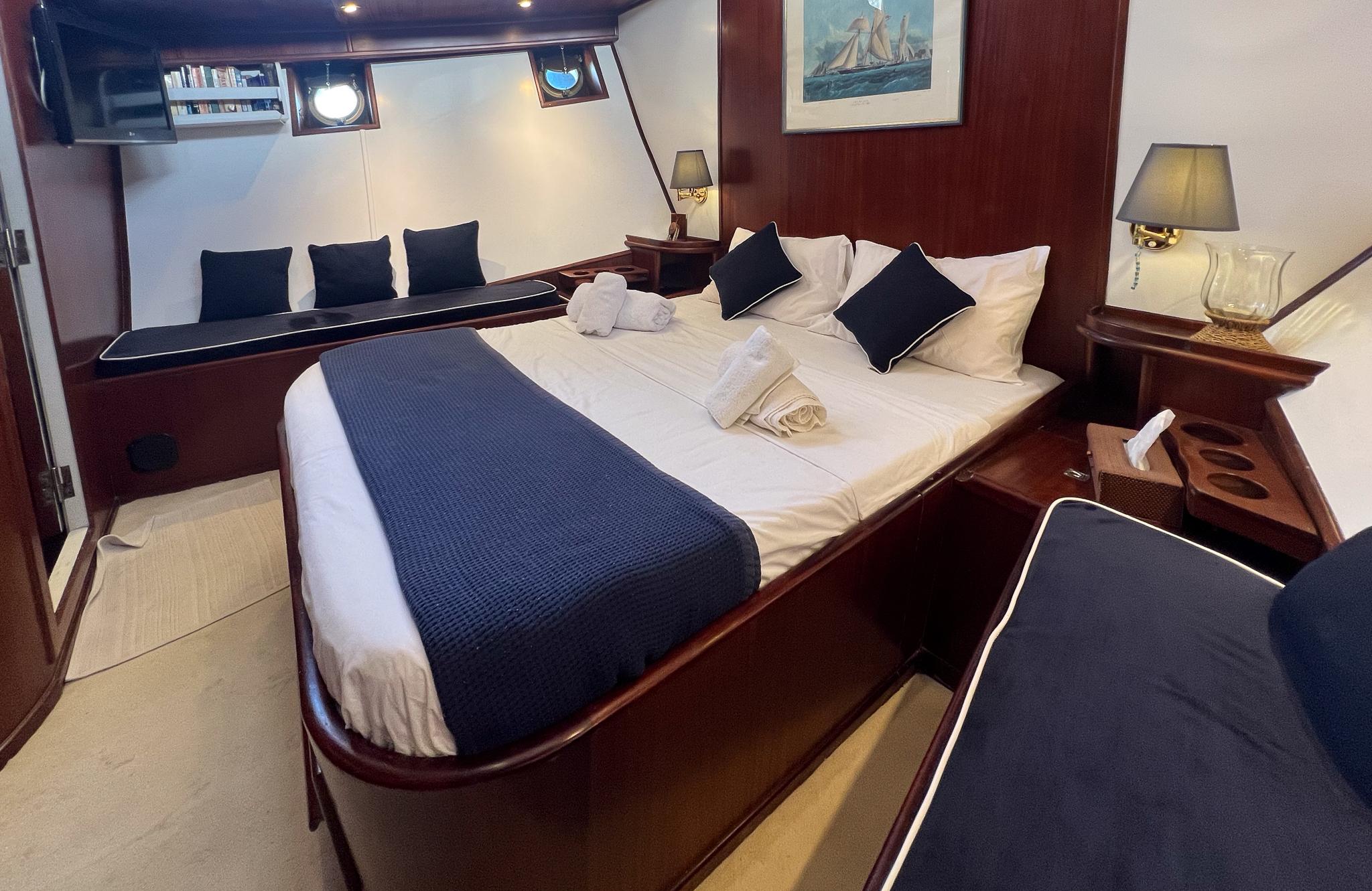 Luxurious cabin interior of 1969 Psarros Shipyard yacht with elegant bedding and decor.