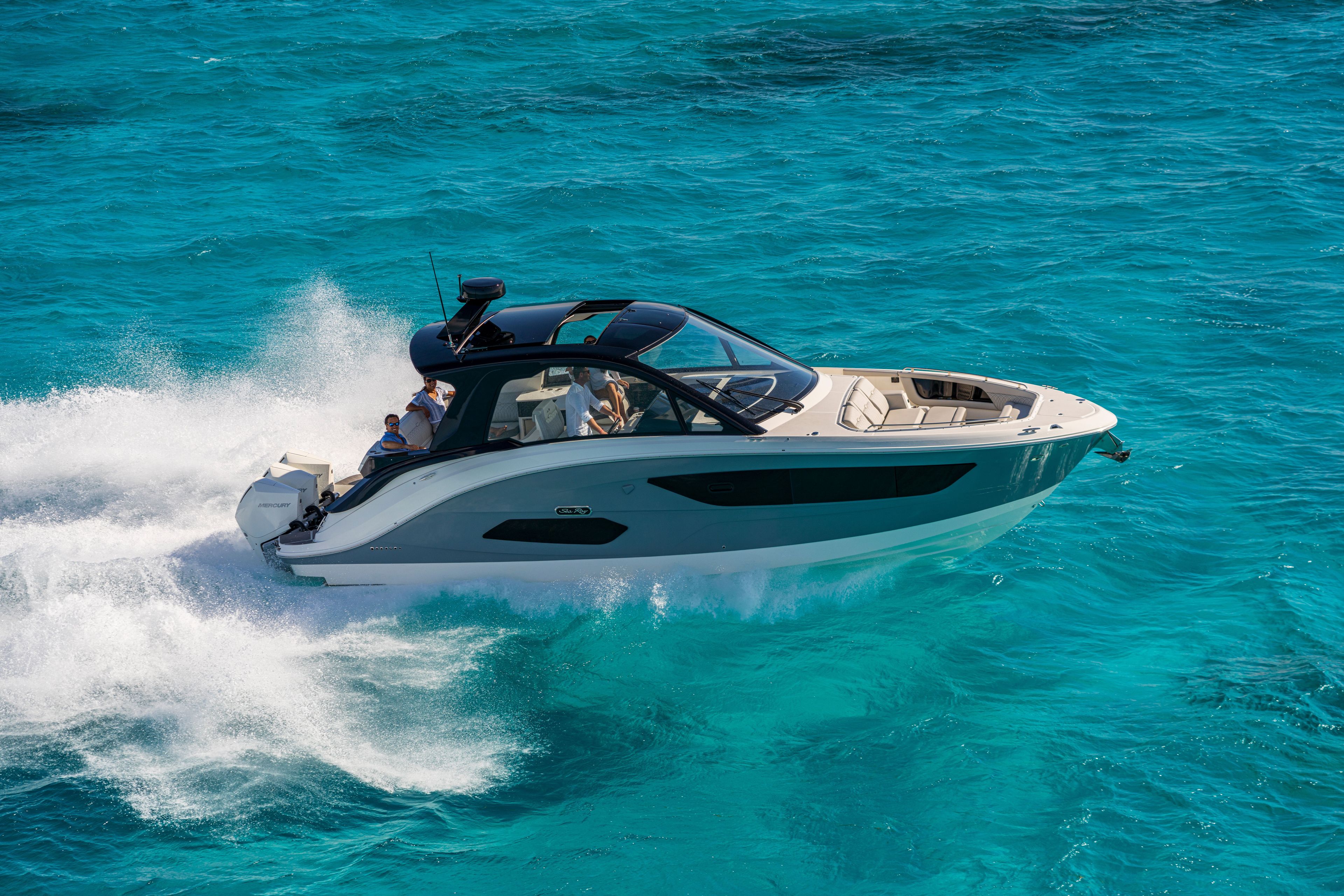 A 2026 Sea Ray Sundancer 370 Outboard speeding across turquoise water.