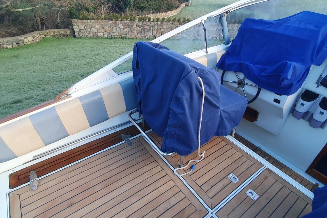 Interior of 1989 Fairey Spearfish MKIII boat with covered seats and wooden deck.