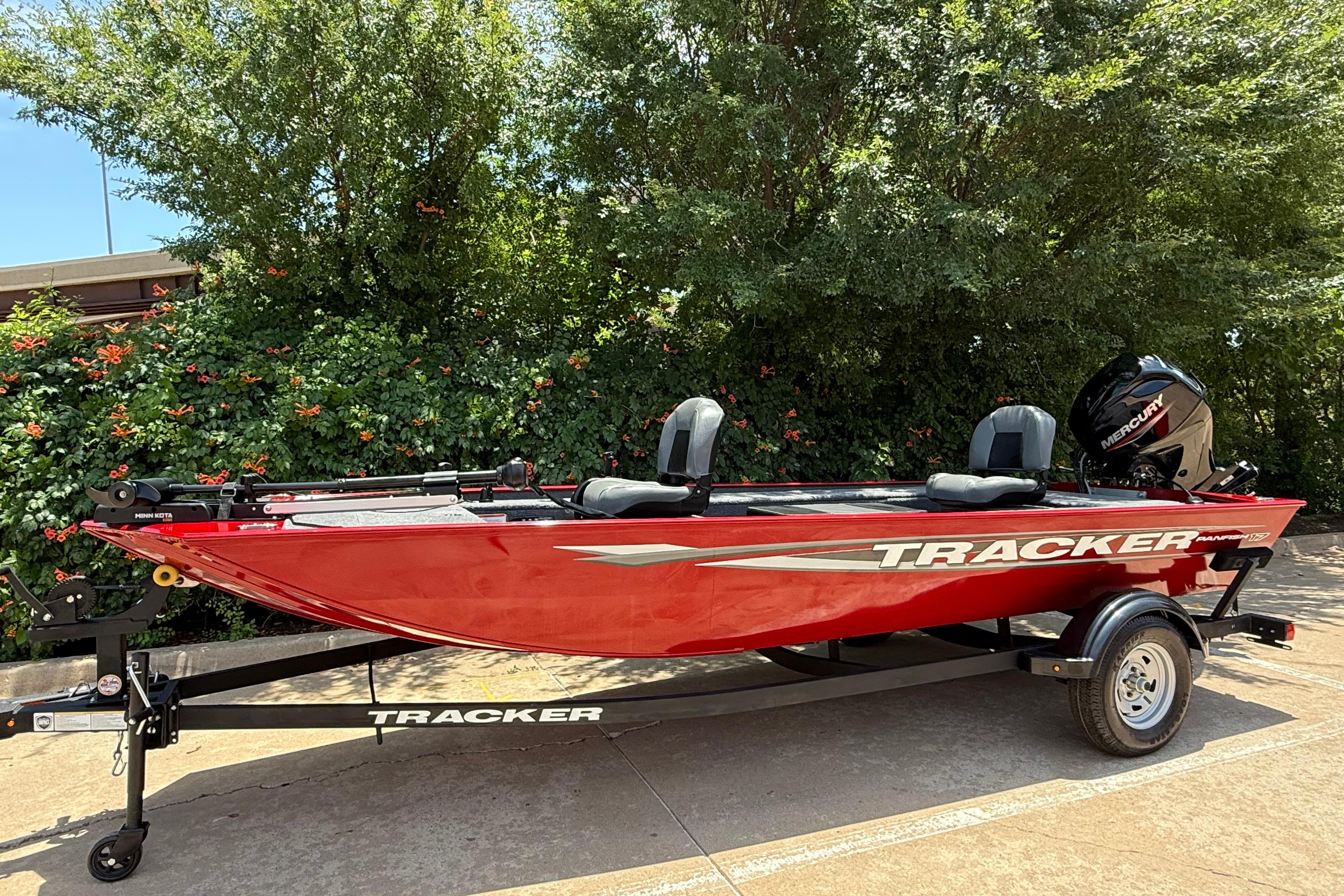 2025 Tracker Panfish 17 boat in vibrant red, parked on a trailer outdoors.