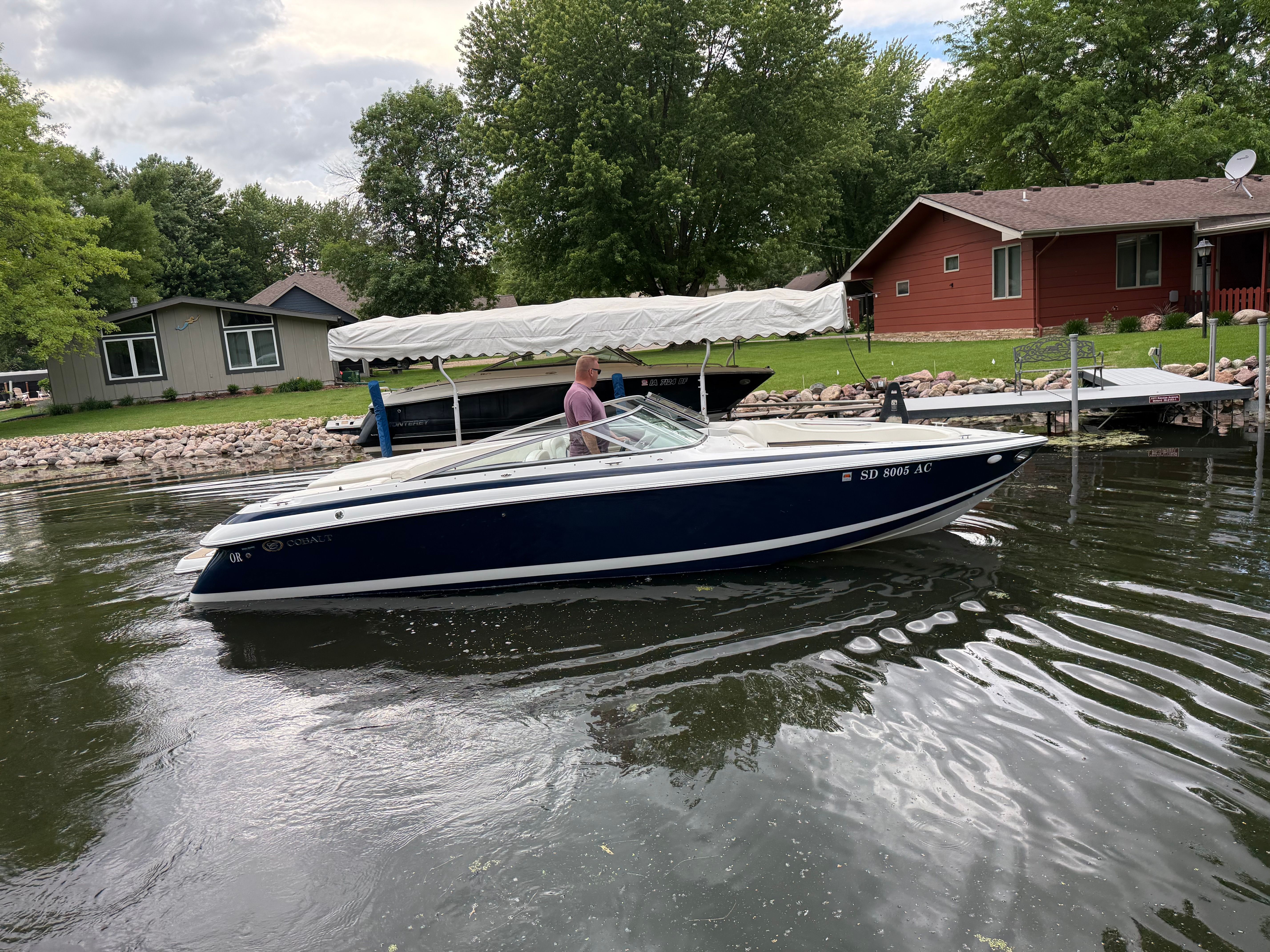 2003 Cobalt 262 boat on a calm lake near dock.