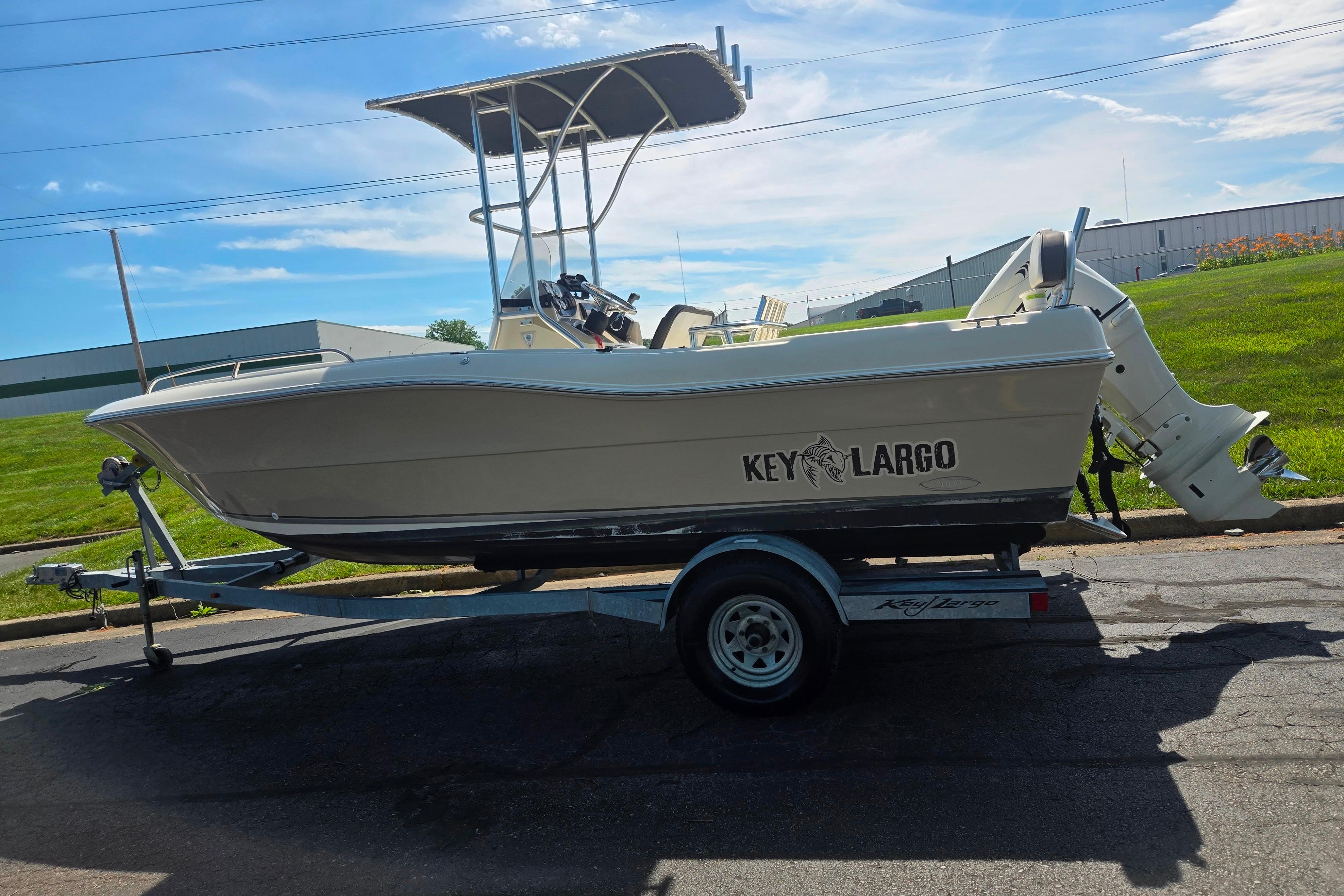 2016 Key Largo 2000CC boat on trailer, parked outdoors under blue sky.