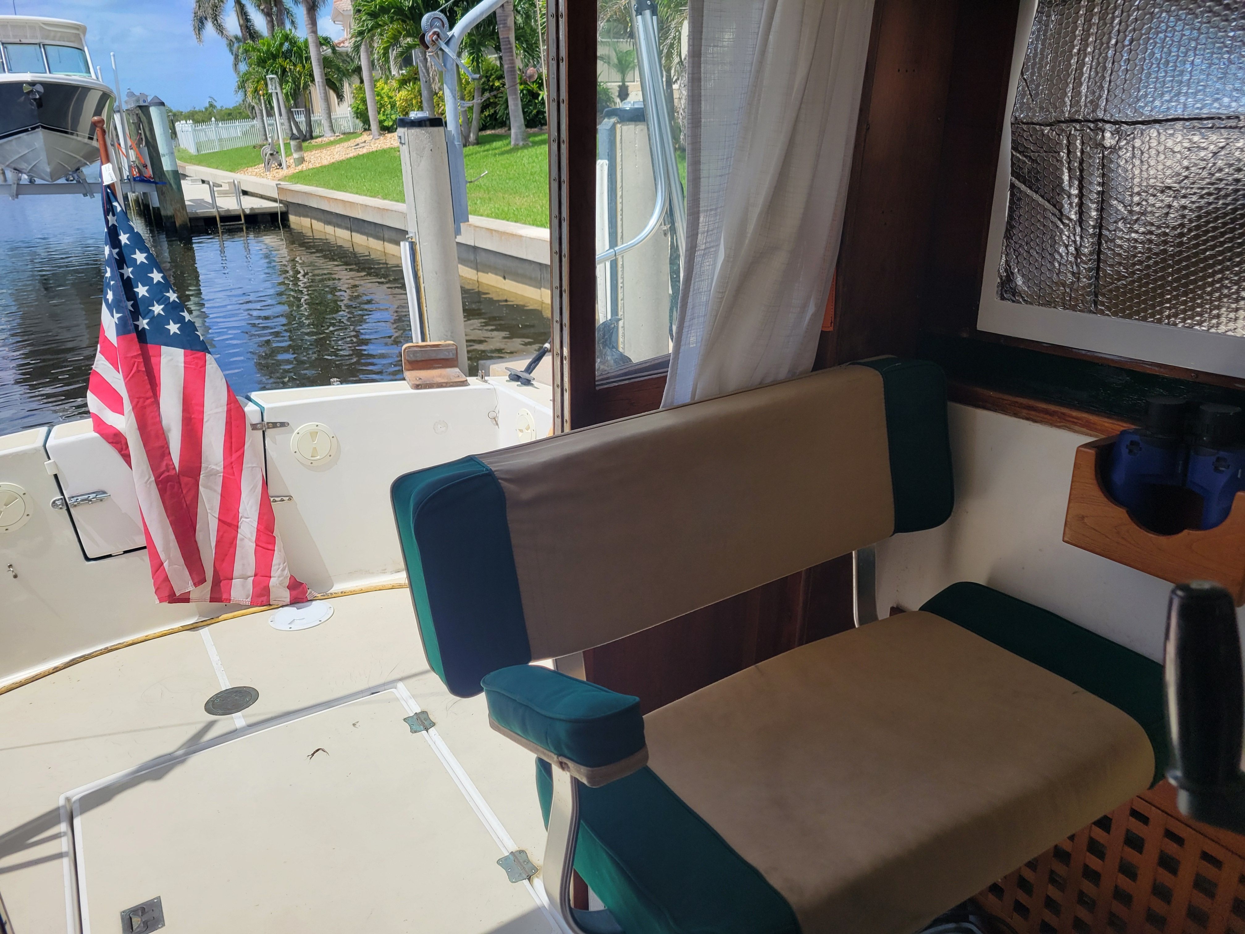 Interior view of a 1989 Cape Dory MS300 with seating and an American flag at the stern.