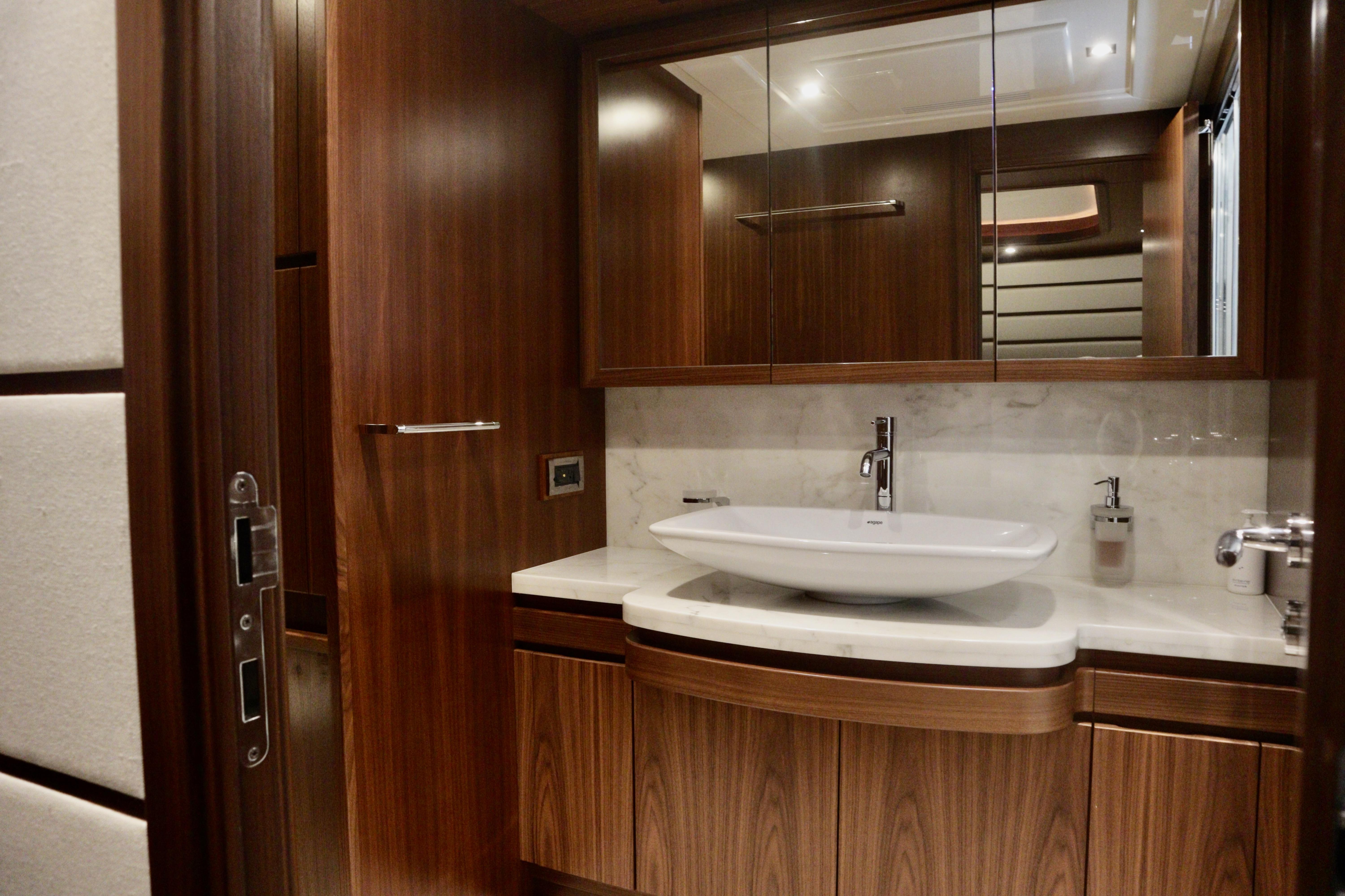 Luxurious bathroom interior on 2016 Custom Line 97 yacht with elegant wood finish.