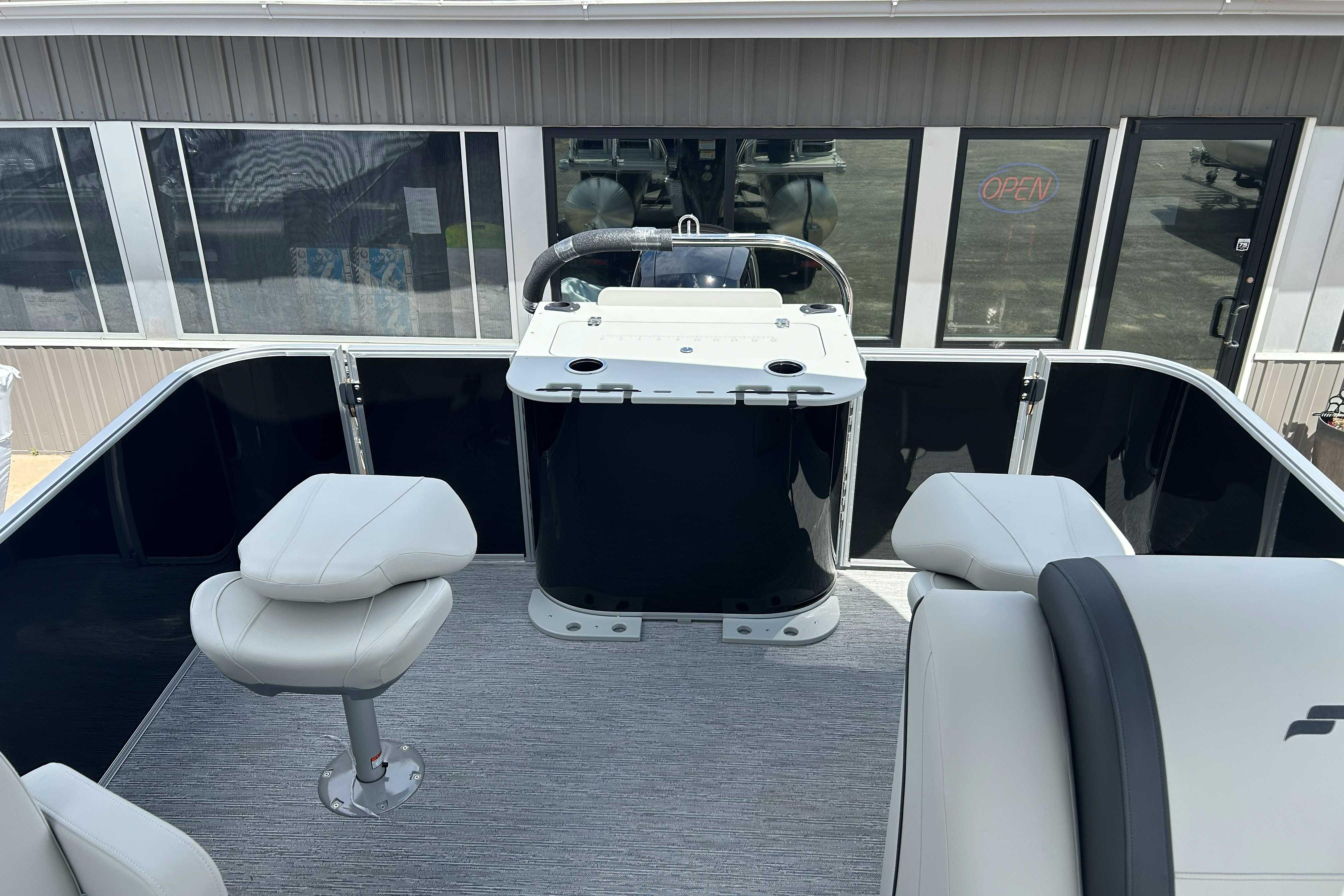 2026 Starcraft EX 22 FD boat interior with seating and helm, docked near a building.
