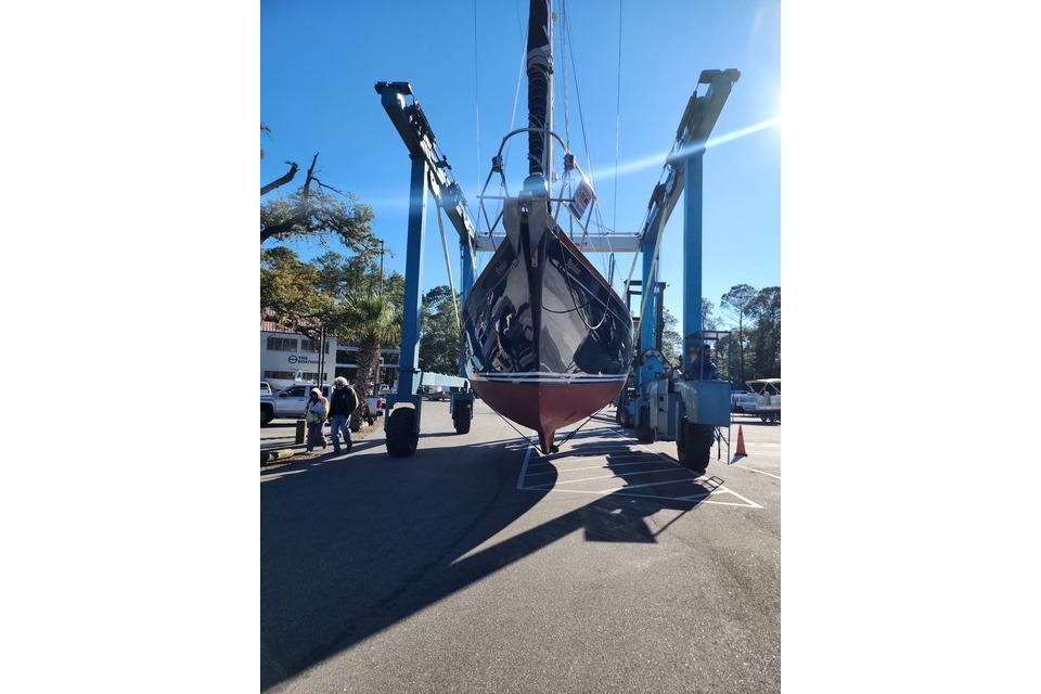 1984 Bristol 45.5 Center Cockpit sailboat being lifted by a crane in a sunny marina.