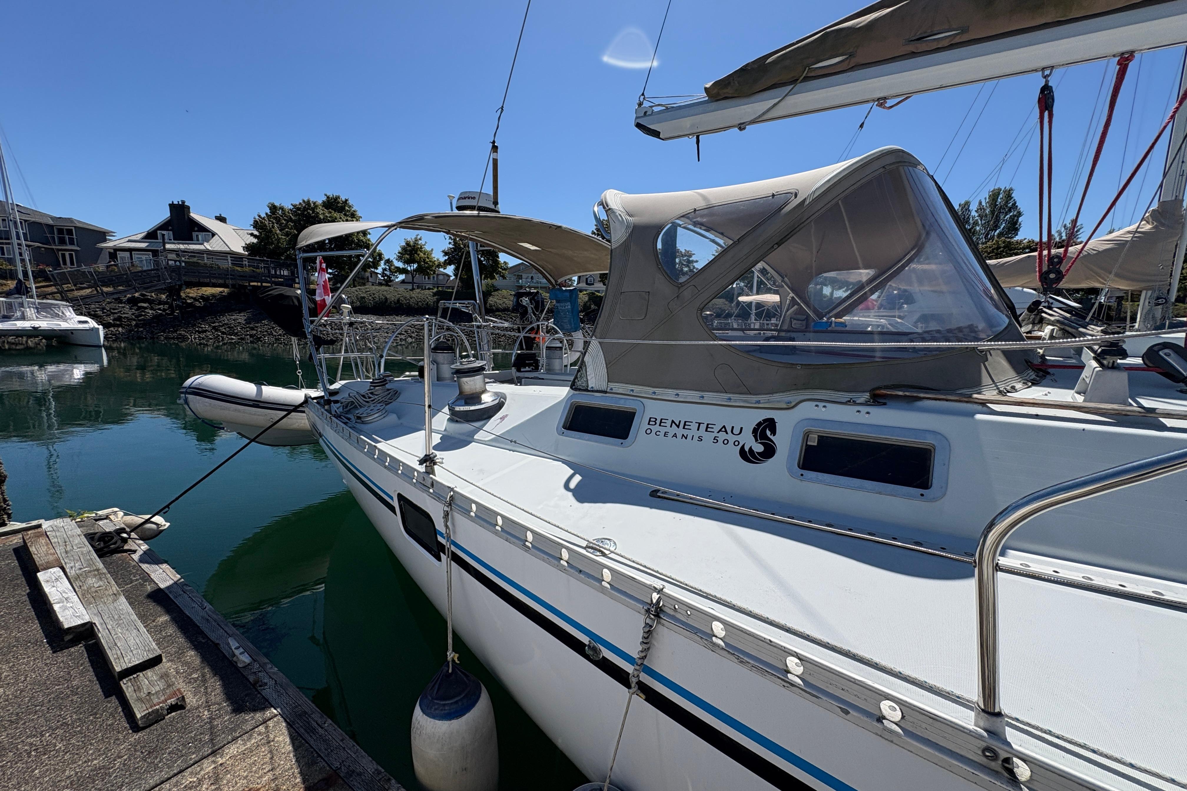 1990 Beneteau Oceanis 500 sailboat docked in a marina under clear blue skies.