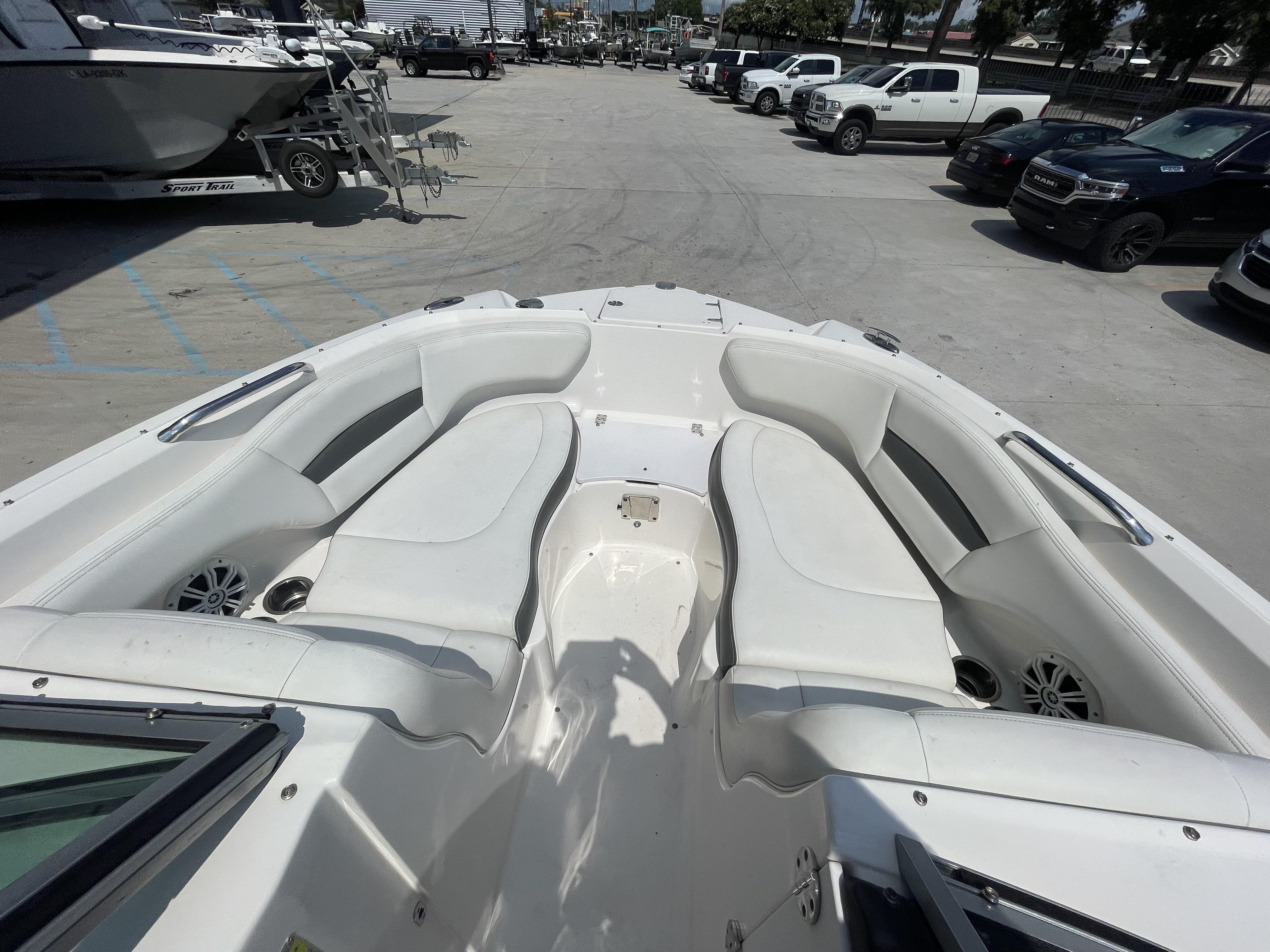 2014 Chaparral Sunesta 224 boat interior with white seating, parked in a lot.