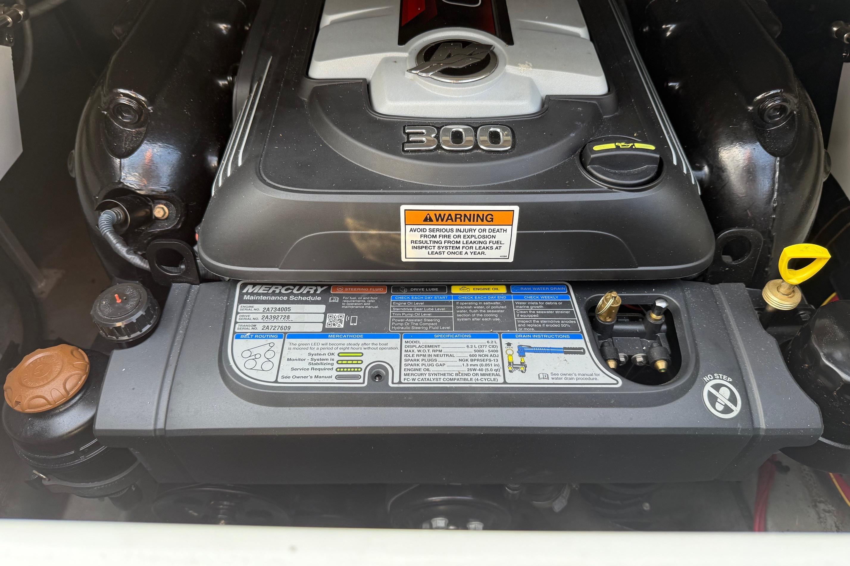 Engine of 2023 Crownline 260 SS boat with Mercury components and warning labels.