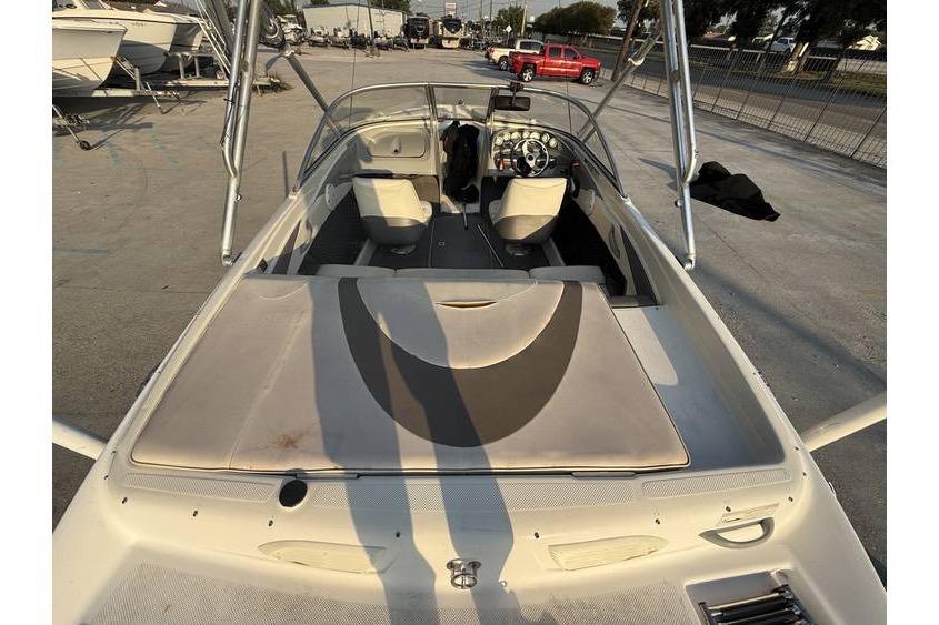 2008 Bayliner 185 Bowrider boat interior, featuring seating and steering wheel, parked outdoors.