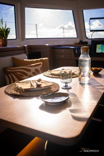 Interior of 2025 Nautitech 48 Open yacht, featuring a sunlit dining area with elegant table setting.
