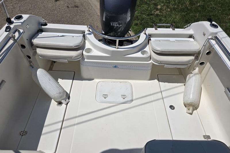 2004 Aquasport 215 Osprey Sport boat interior with motor and seating.
