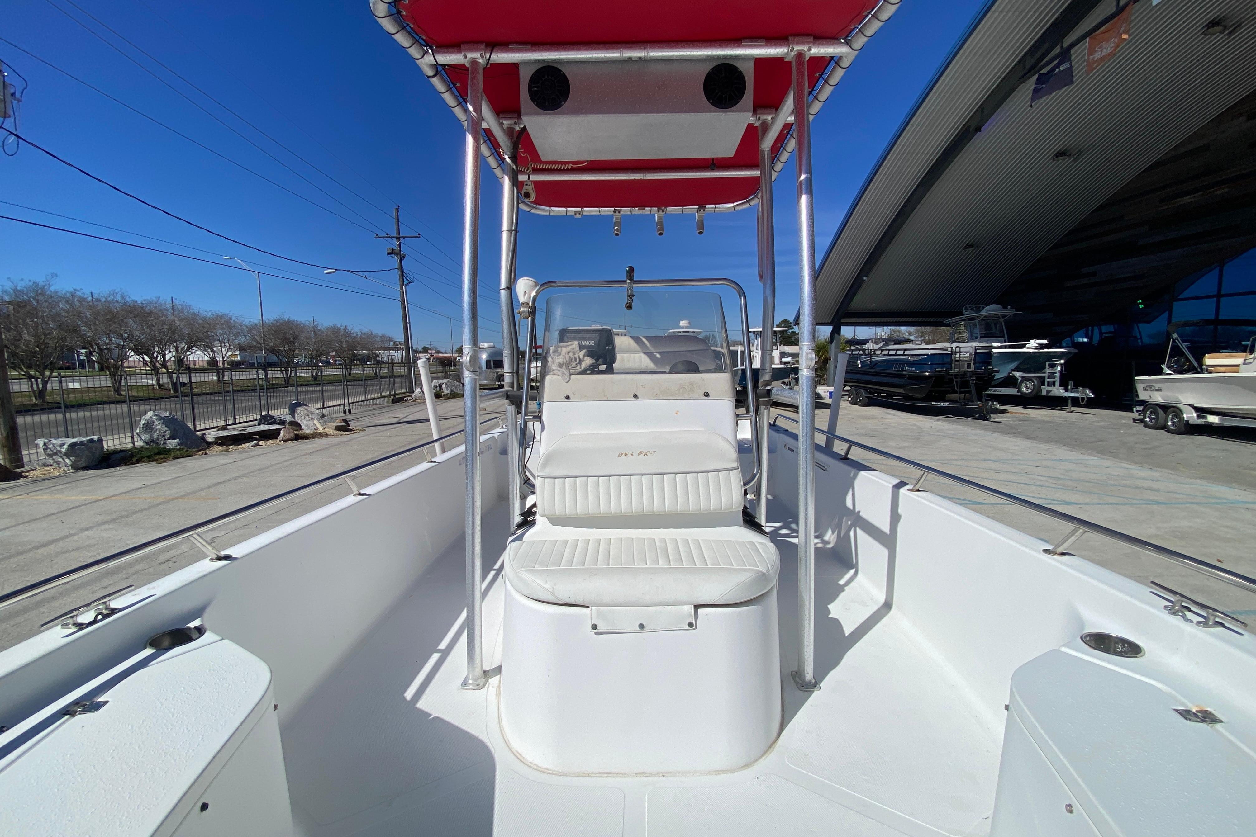 2005 Sea Pro SV2400CC Bay Boat with red canopy, docked under clear blue sky.