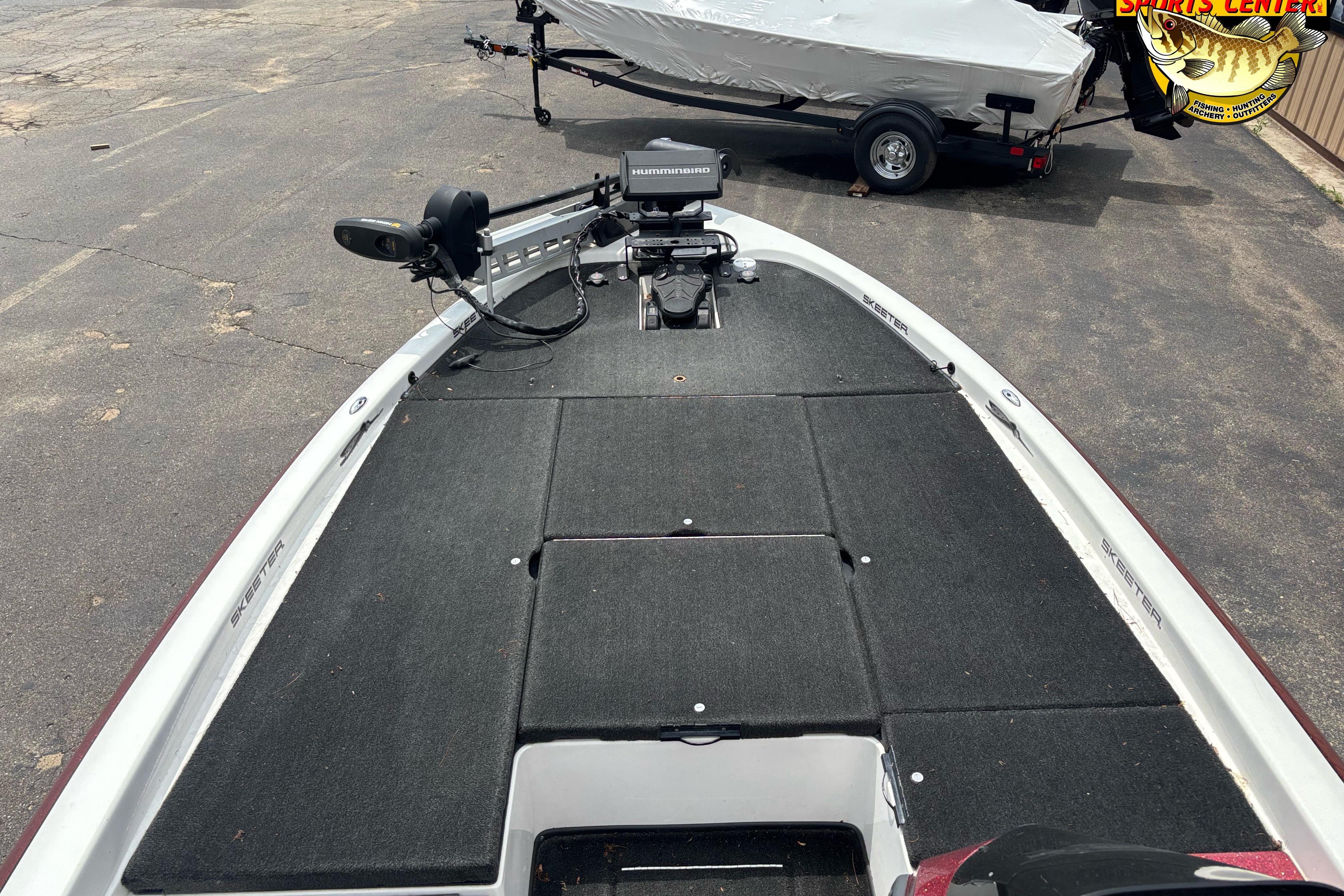 2013 Skeeter ZX20 boat deck with trolling motor and electronics, parked on pavement.