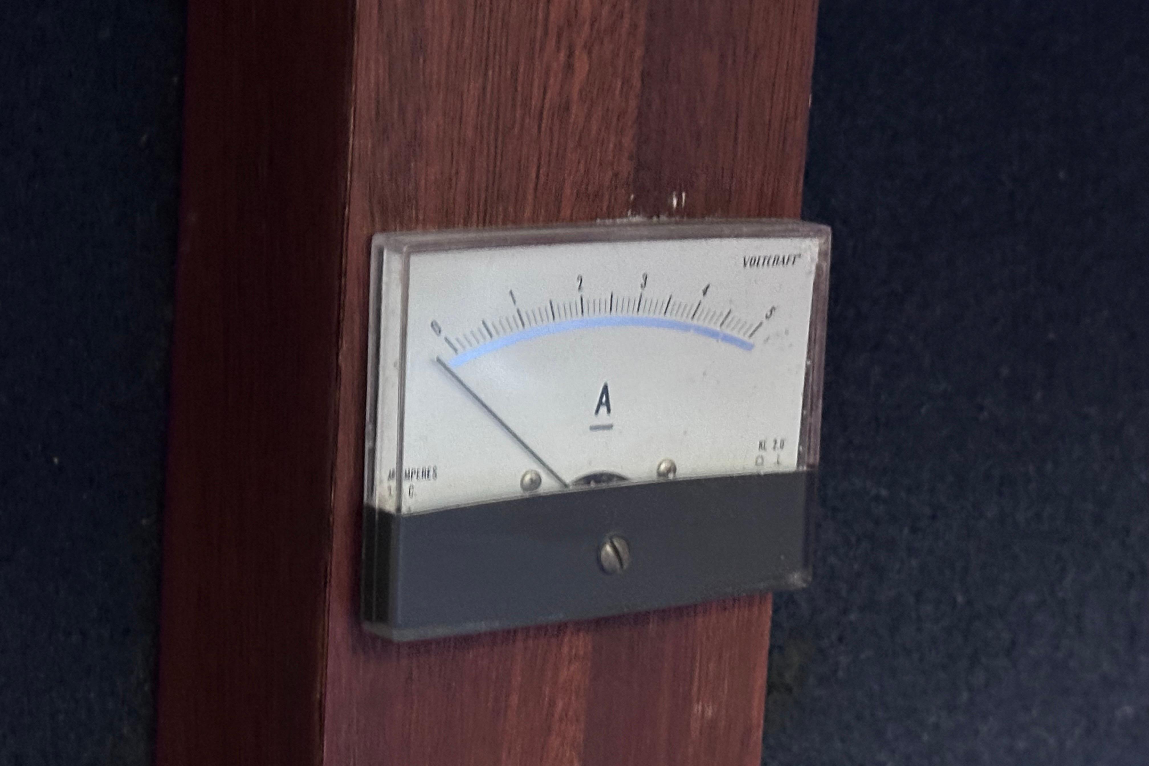 Analog ammeter on 1980 Hallberg-Rassy 352 yacht, mounted on wooden panel.