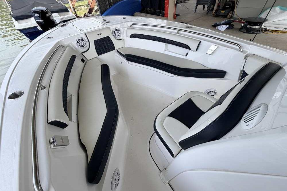 2024 Tidewater 232 LXF boat interior with cushioned seating and speakers.