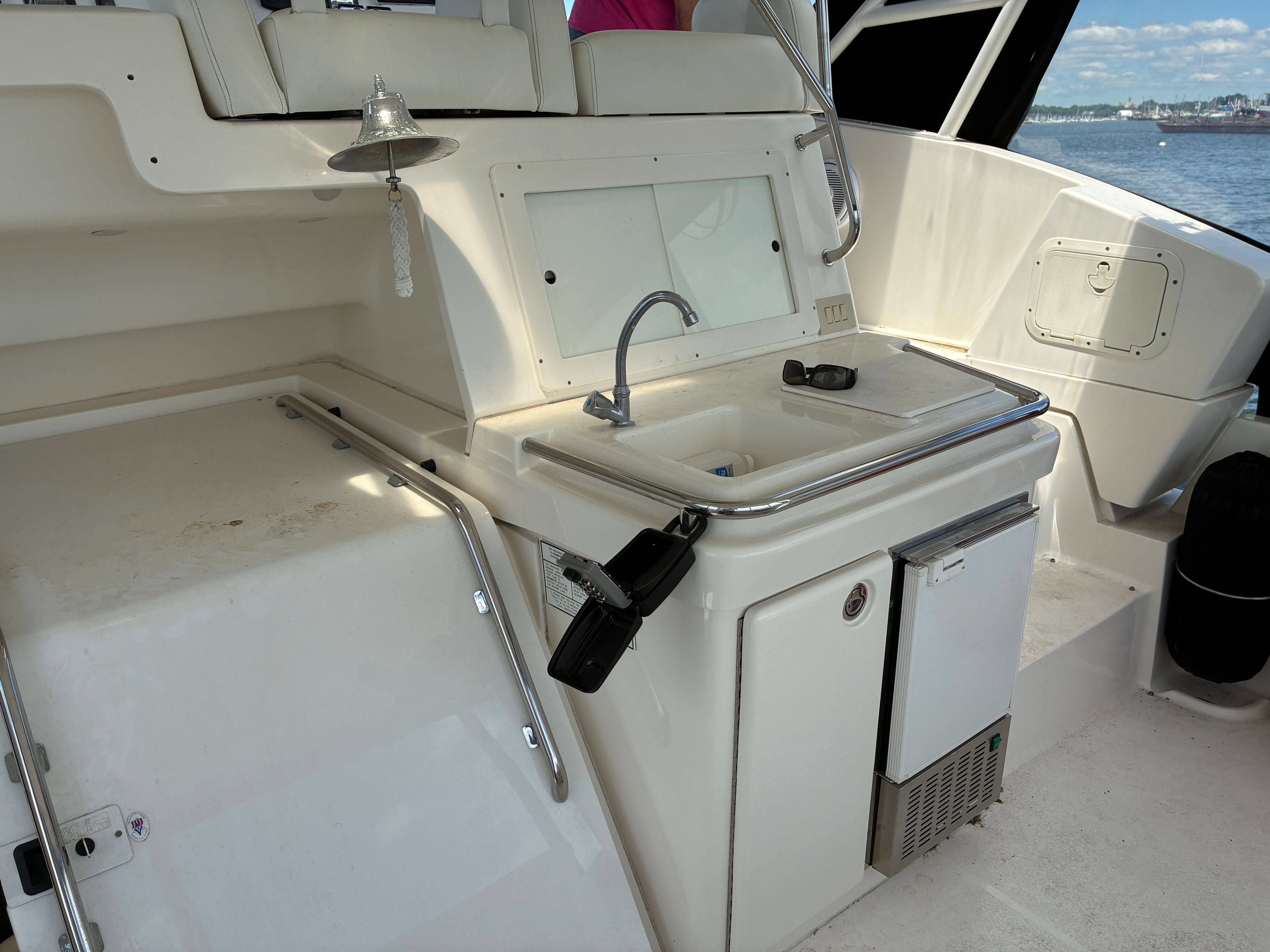 The 2001 Silverton 392 Motor Yacht features an outdoor kitchen with a sink and refrigerator.