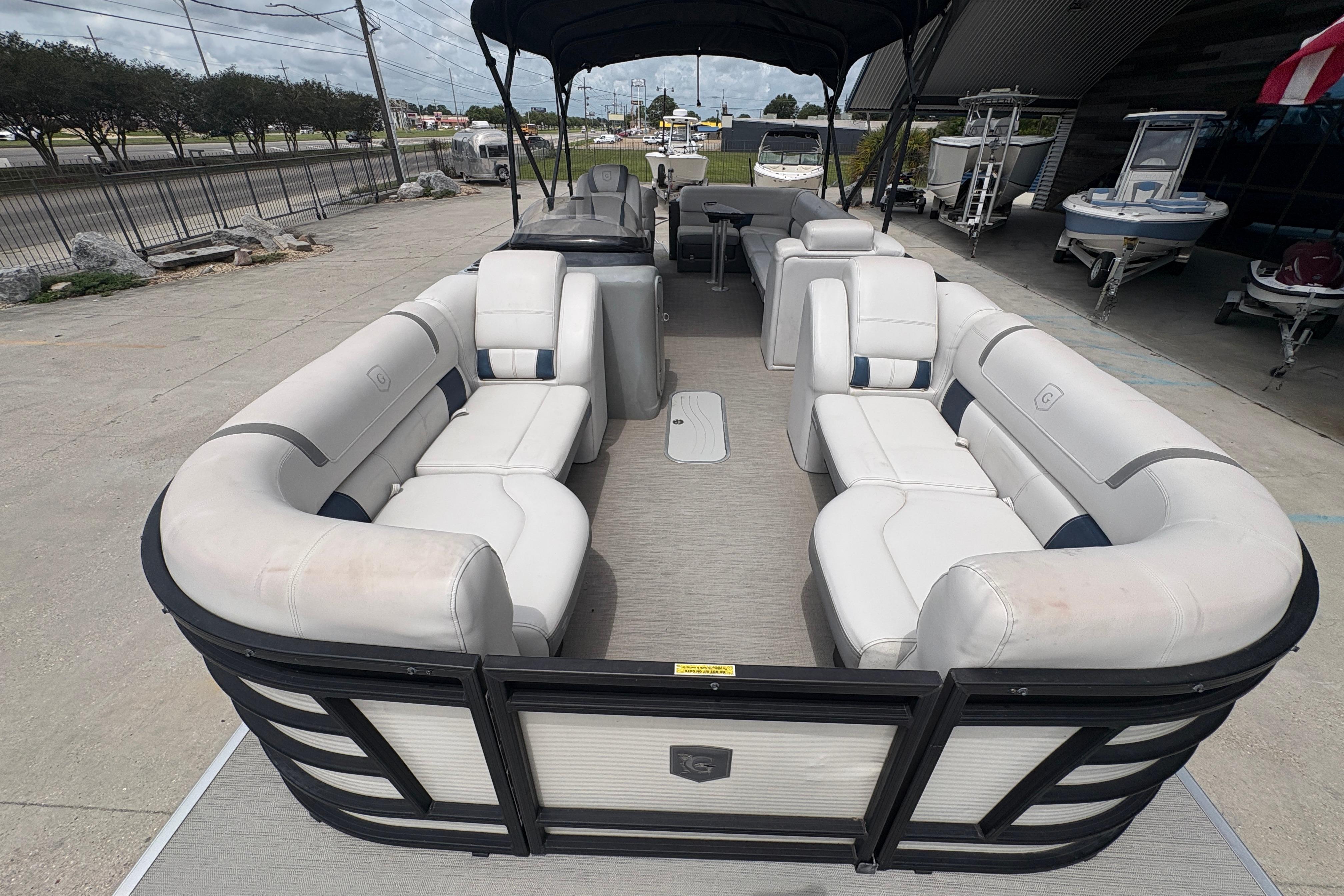 2019 Godfrey Aqua Patio pontoon boat with spacious seating and canopy, parked outdoors.