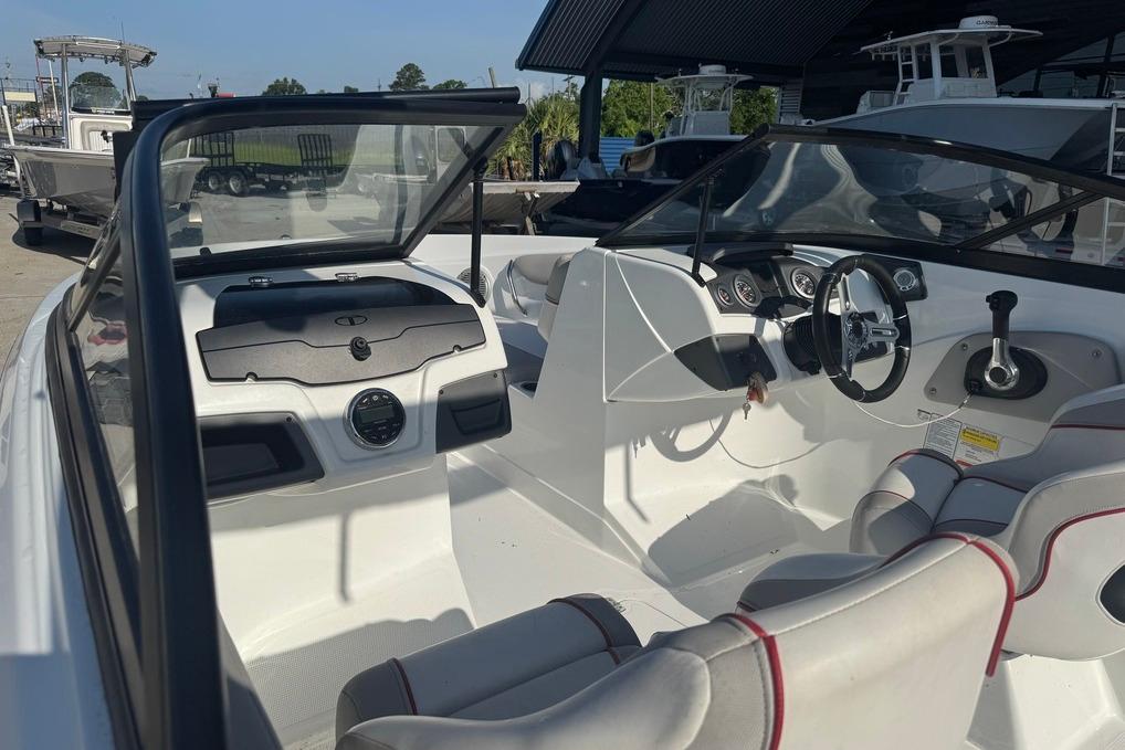 2018 Tahoe 700 TF boat interior with steering wheel and seating, docked outdoors.