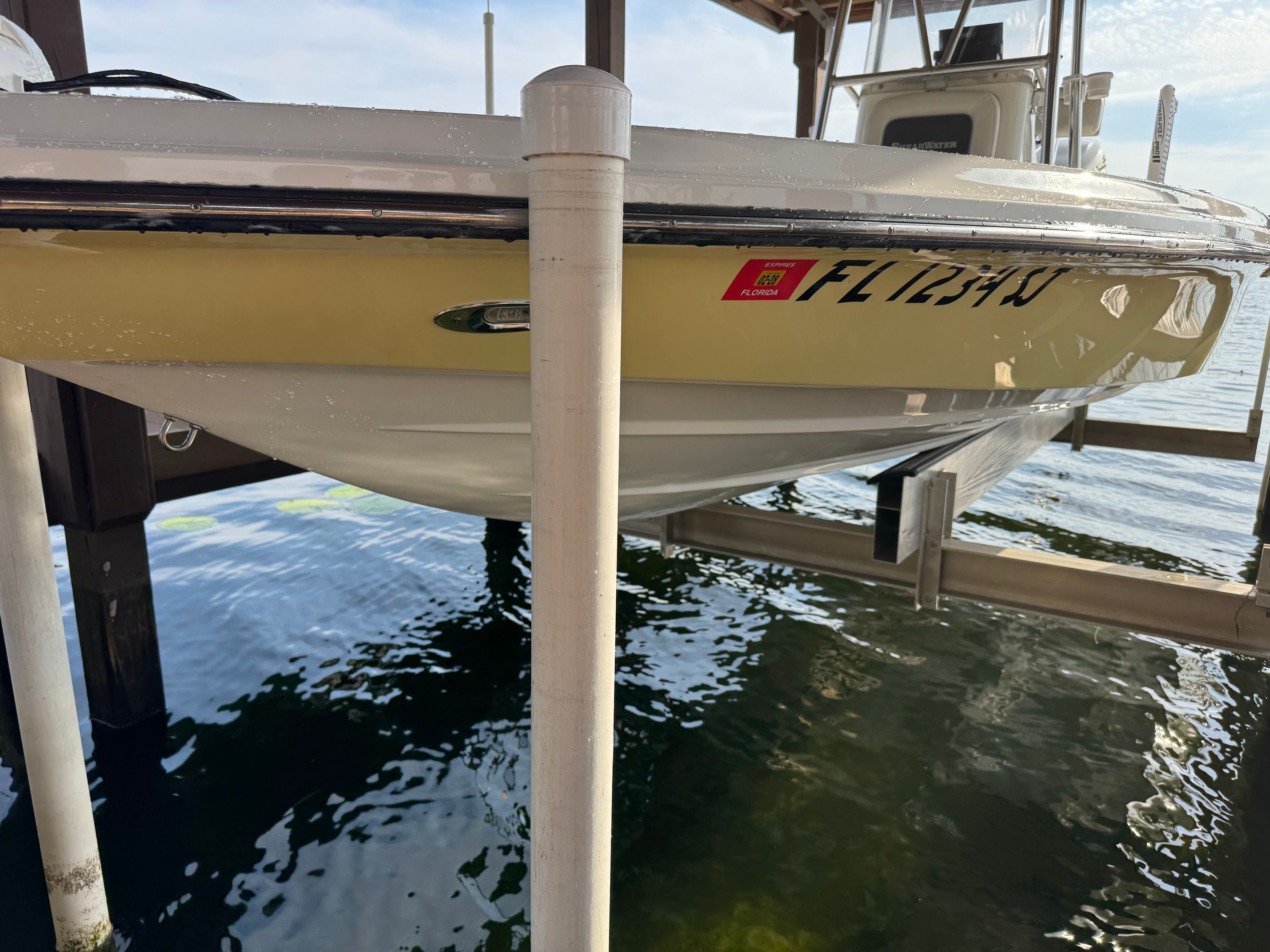 2004 ShearWater LTZ boat on a boat lift by the water.