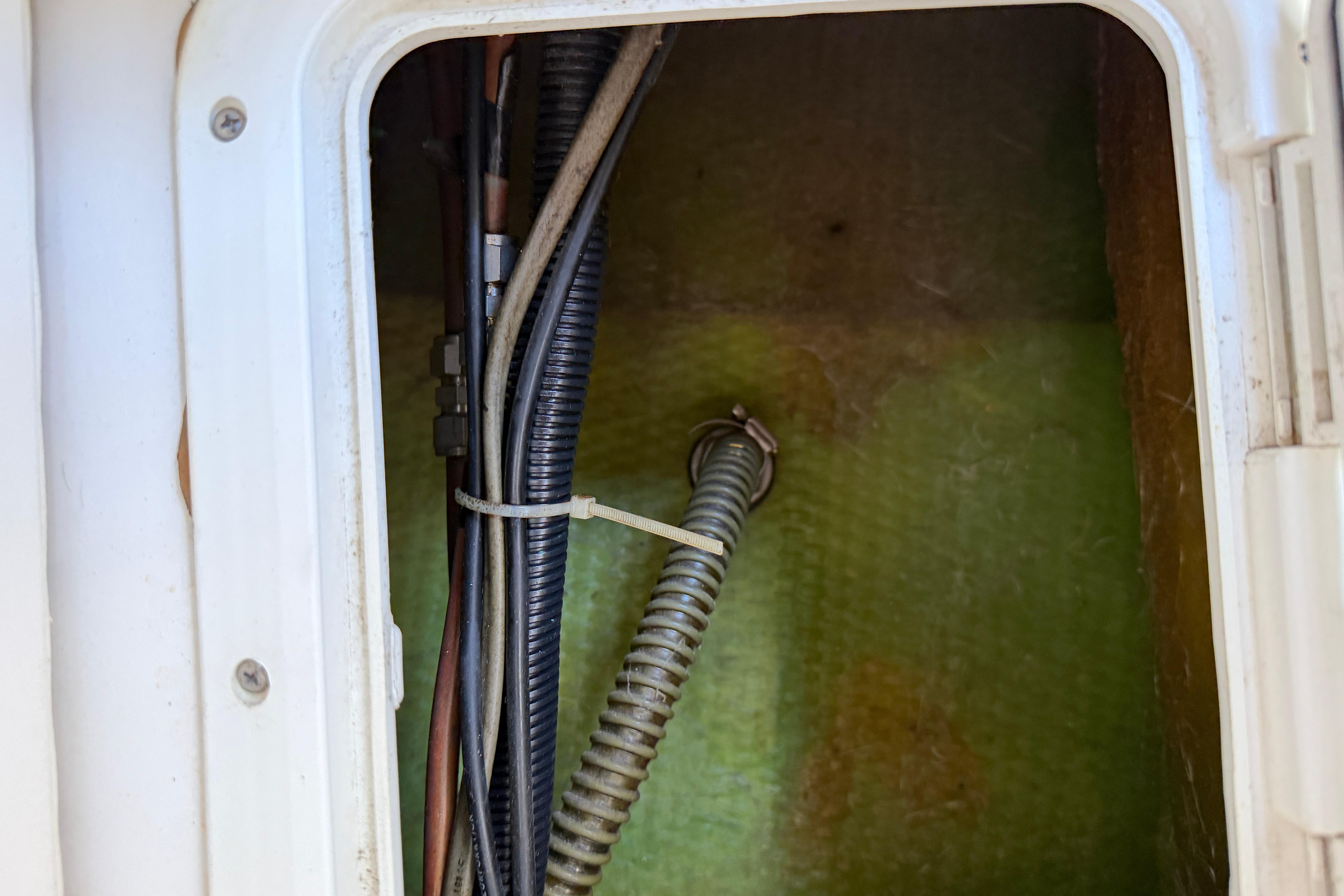 Interior view of a 1987 Grady-White Seafarer 226 boat compartment with wiring and tubing.