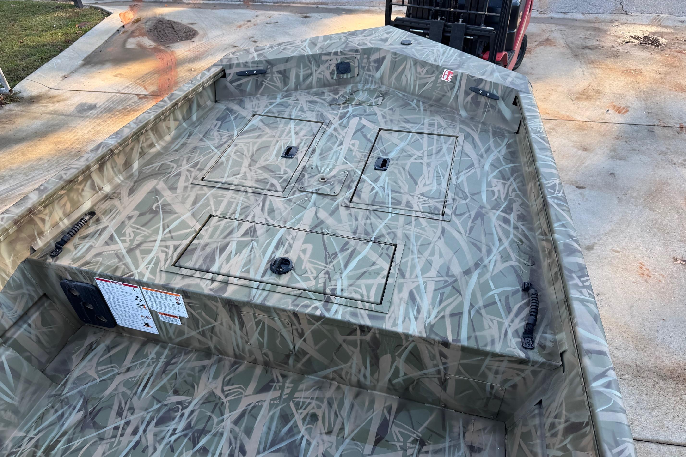 2026 Crestliner 1860 Retriever CC boat with camouflage design on a concrete surface.