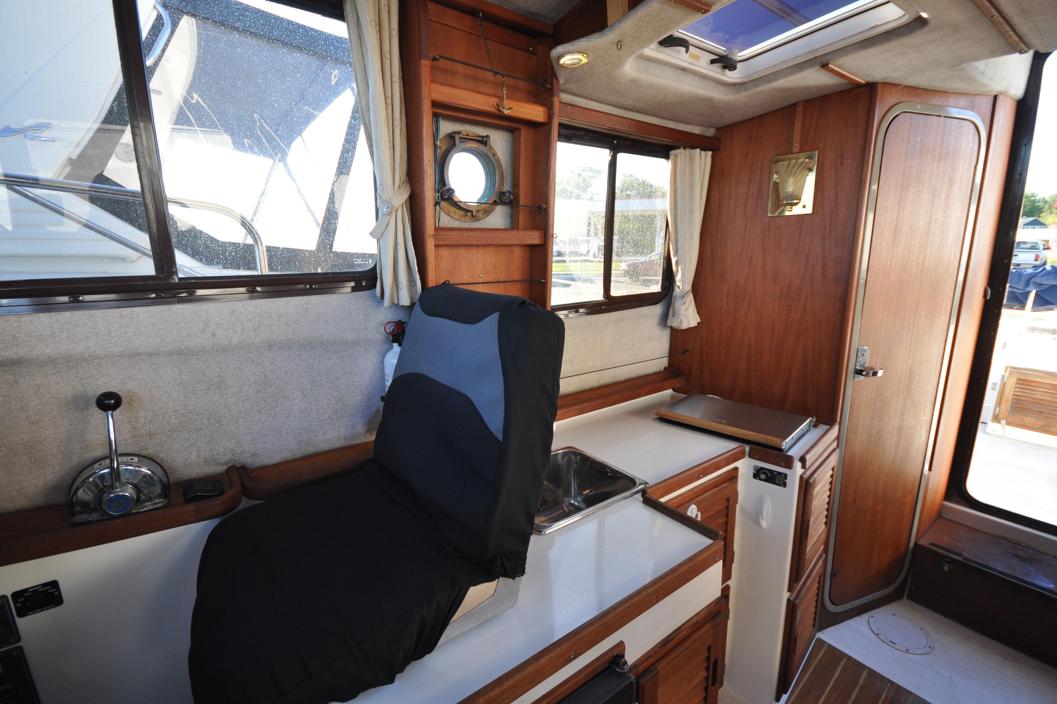 Interior of a 2007 Ranger Tug R-25 boat with wooden cabinetry and seating.