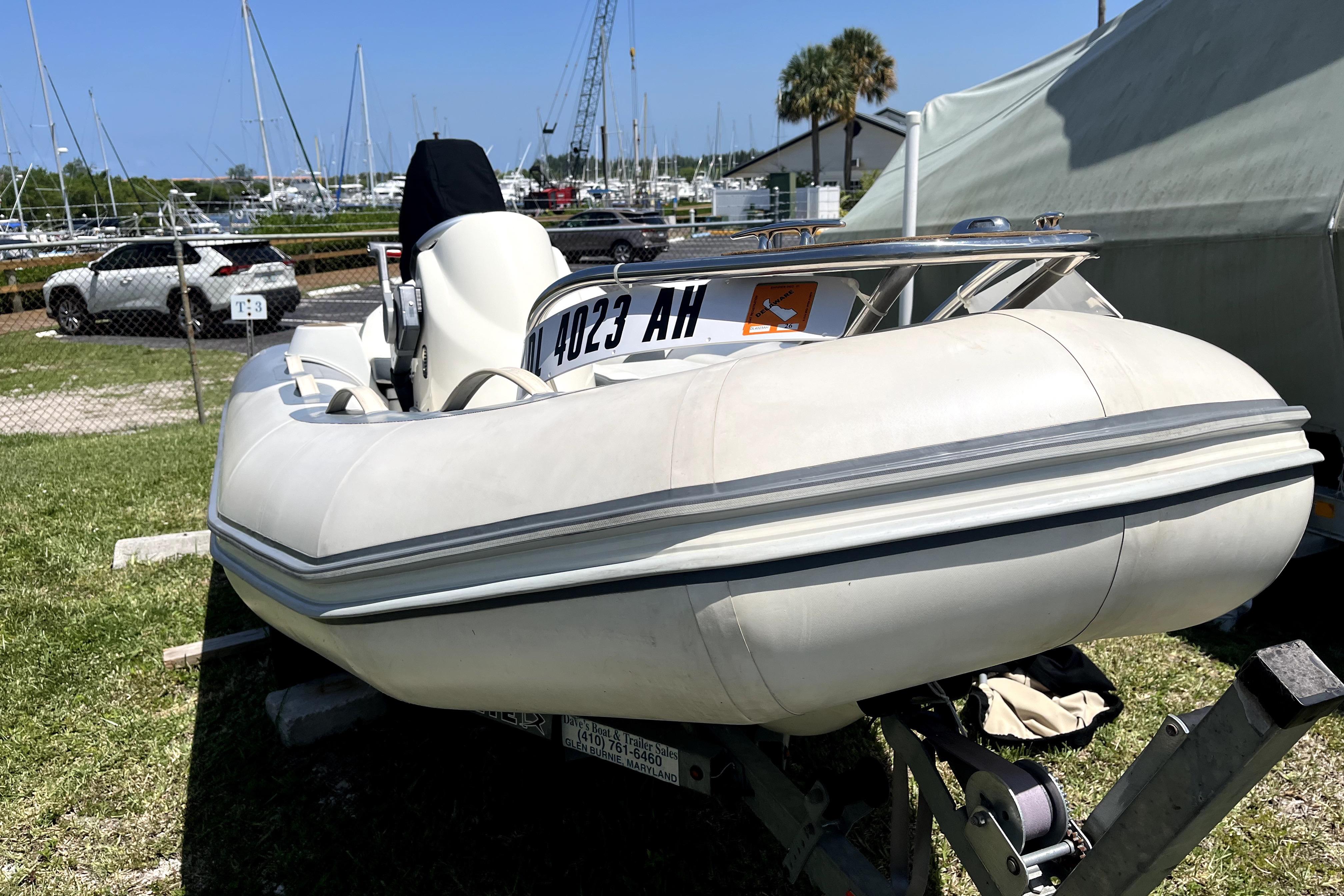 Inflatable boat on trailer near marina, with Sea Ray 60 Sundancer, 2008 model.