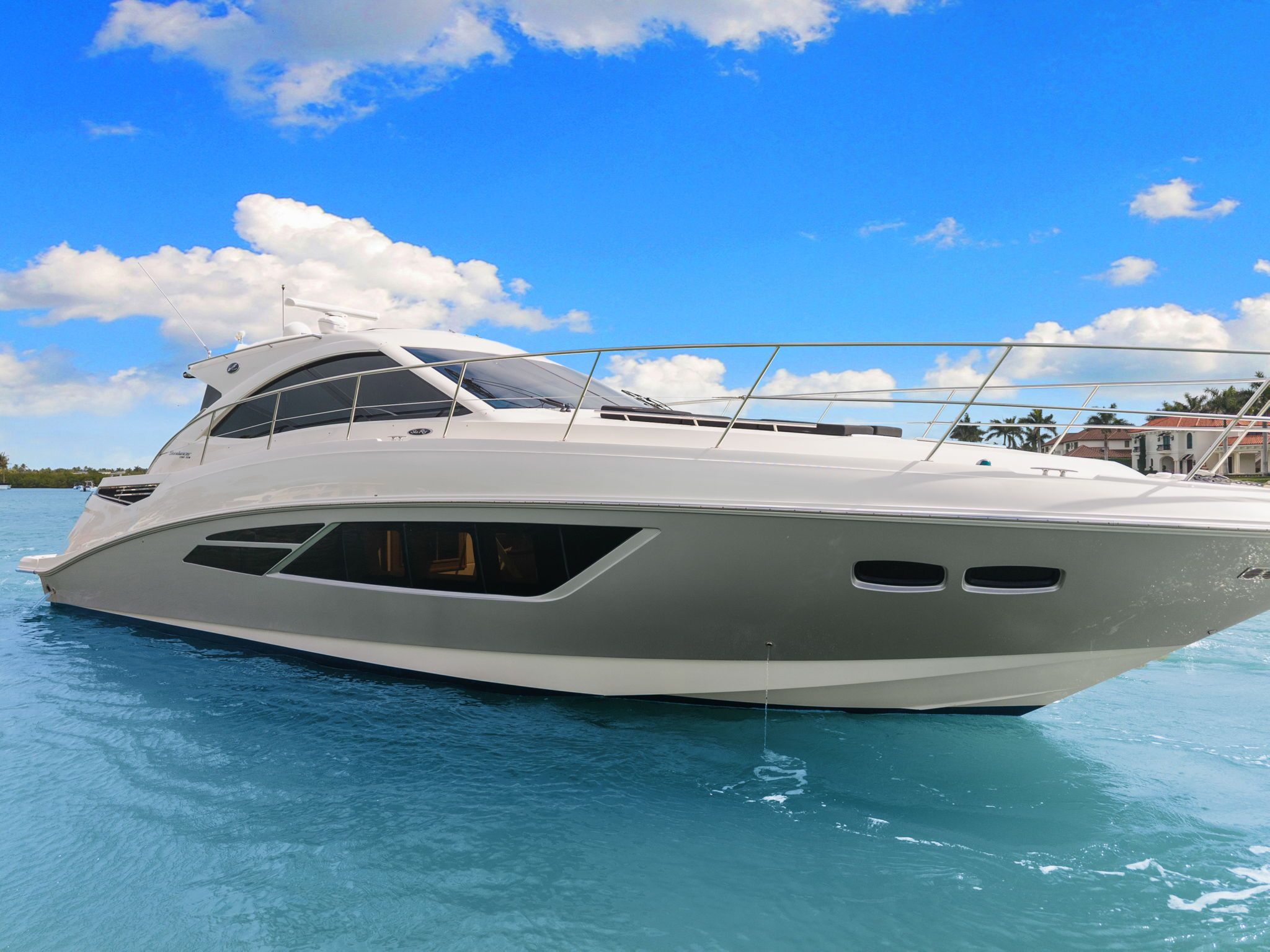 The 2017 Sea Ray Sundancer 510 glides elegantly on blue water under a clear sky.