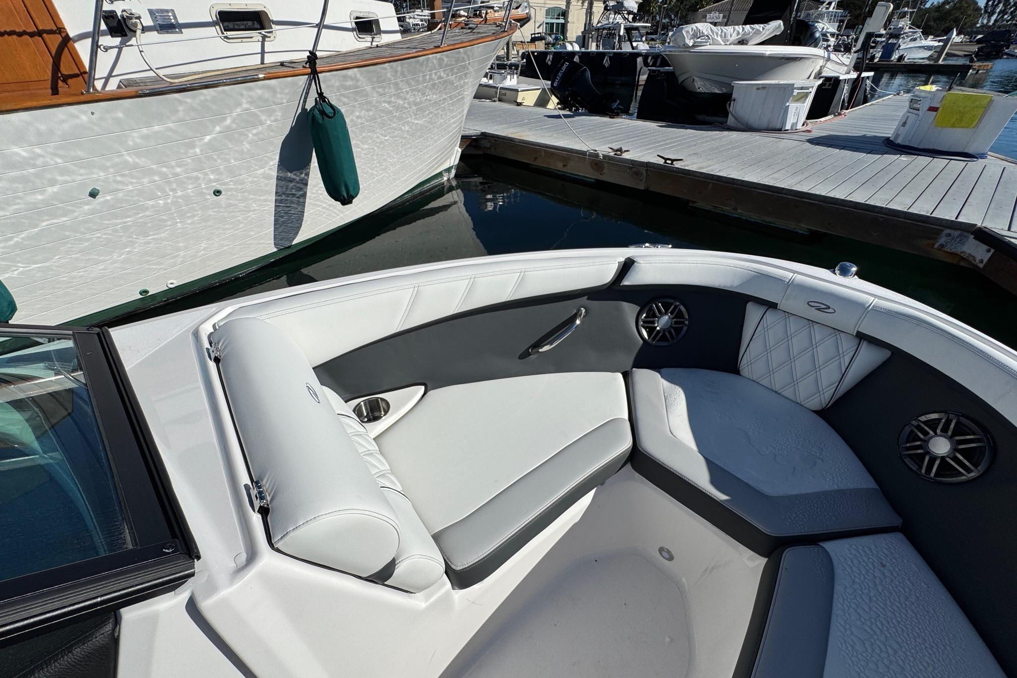 Interior of 2026 Regal 21 OBX boat with white and gray seating at a marina.