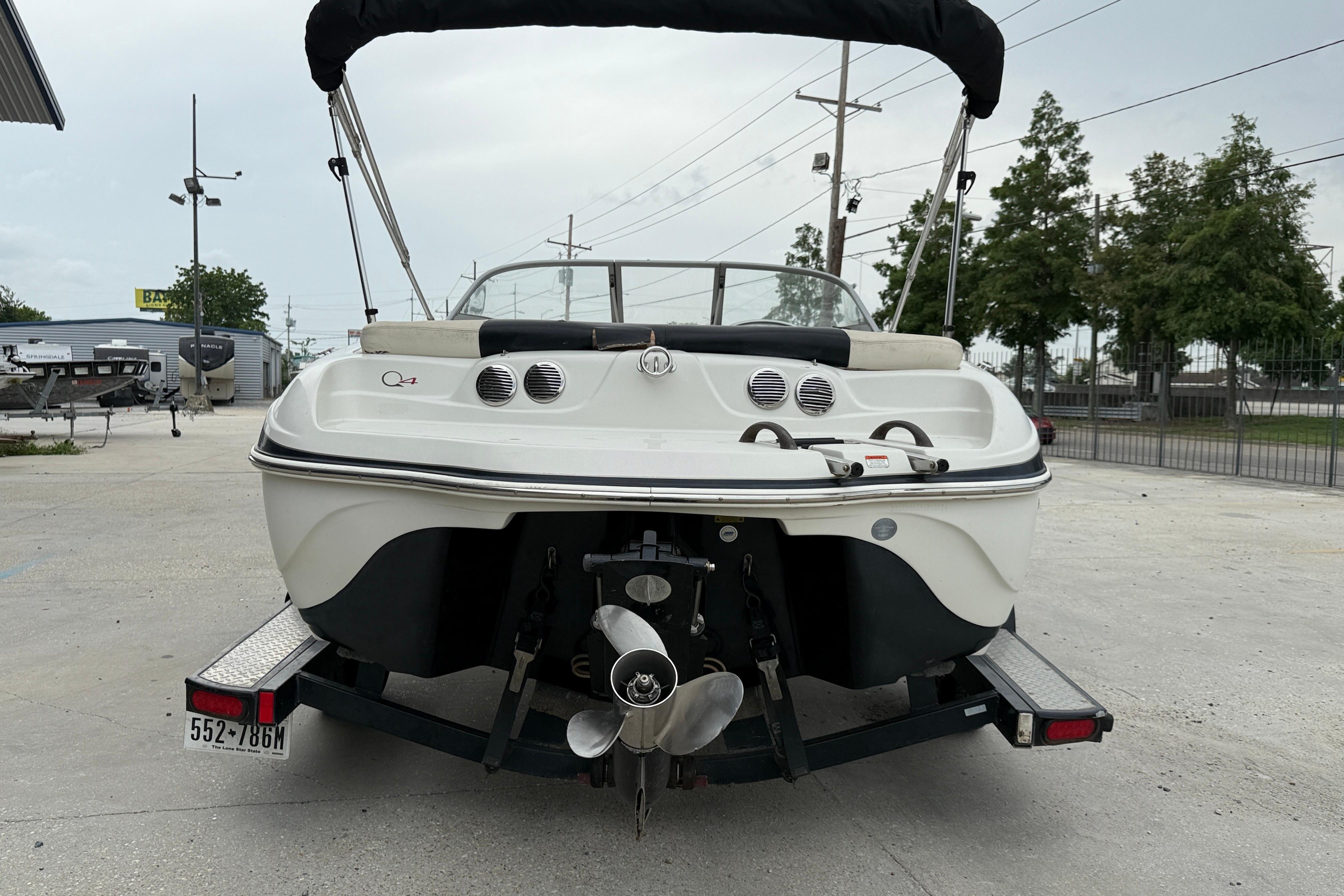 2010 Tahoe Q4 boat on trailer, rear view, parked outdoors.