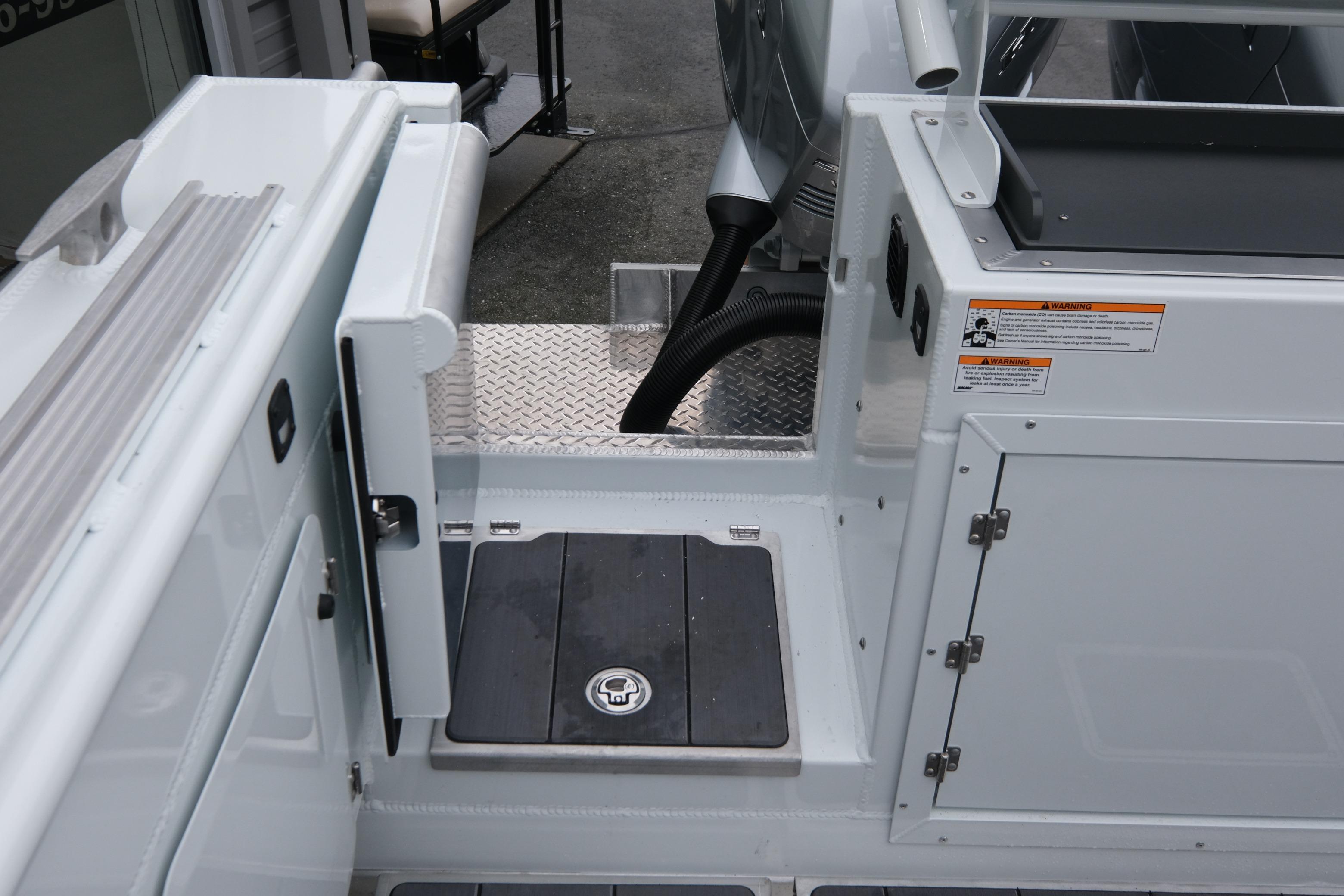 2026 Hewescraft 270 Pacific Explorer boat deck with storage compartments and safety warnings.