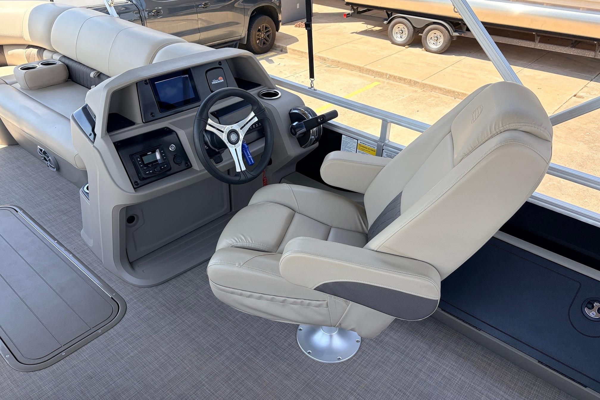 2024 Sun Tracker SportFish 22 XP3 boat interior with captain's chair and steering console.
