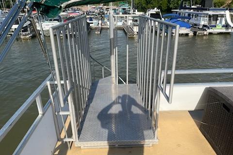 1995 Myacht 40X13 houseboat with metal railing, docked at a marina.