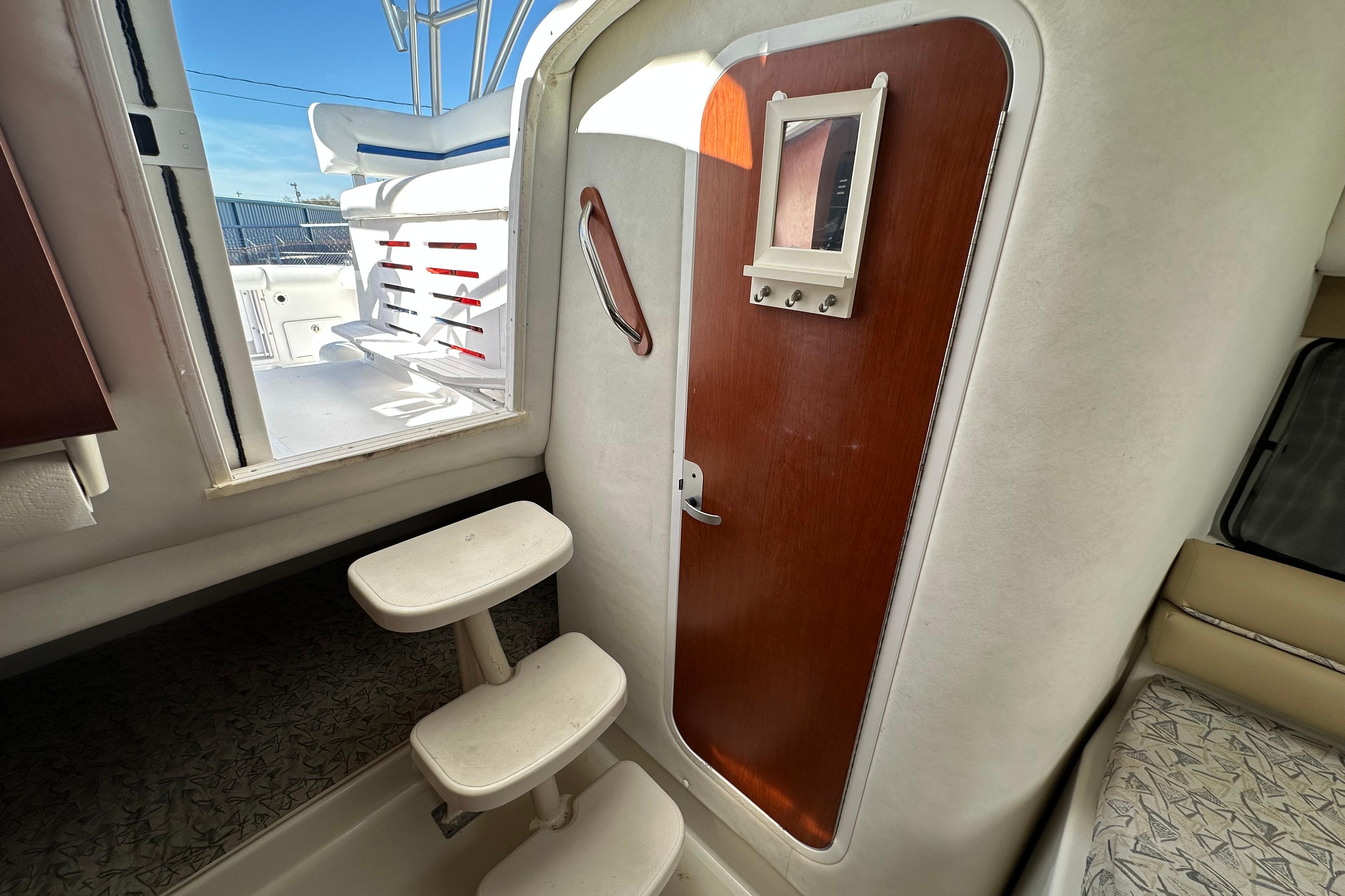 Interior view of 2006 Pro-Line 32 Express boat with steps and wooden door.