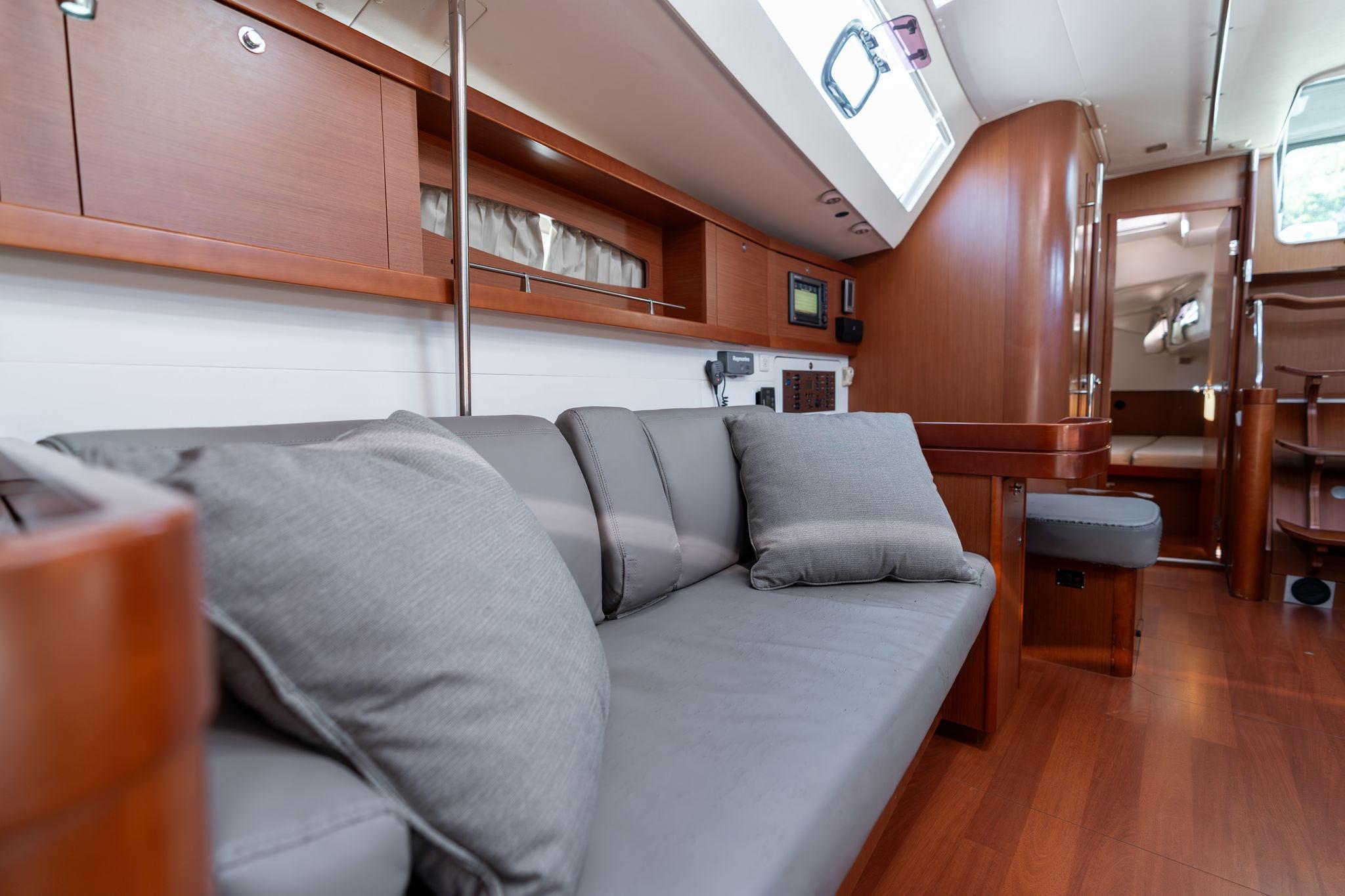 Interior of 2013 Beneteau Oceanis 50 yacht with modern wood finish and gray seating.