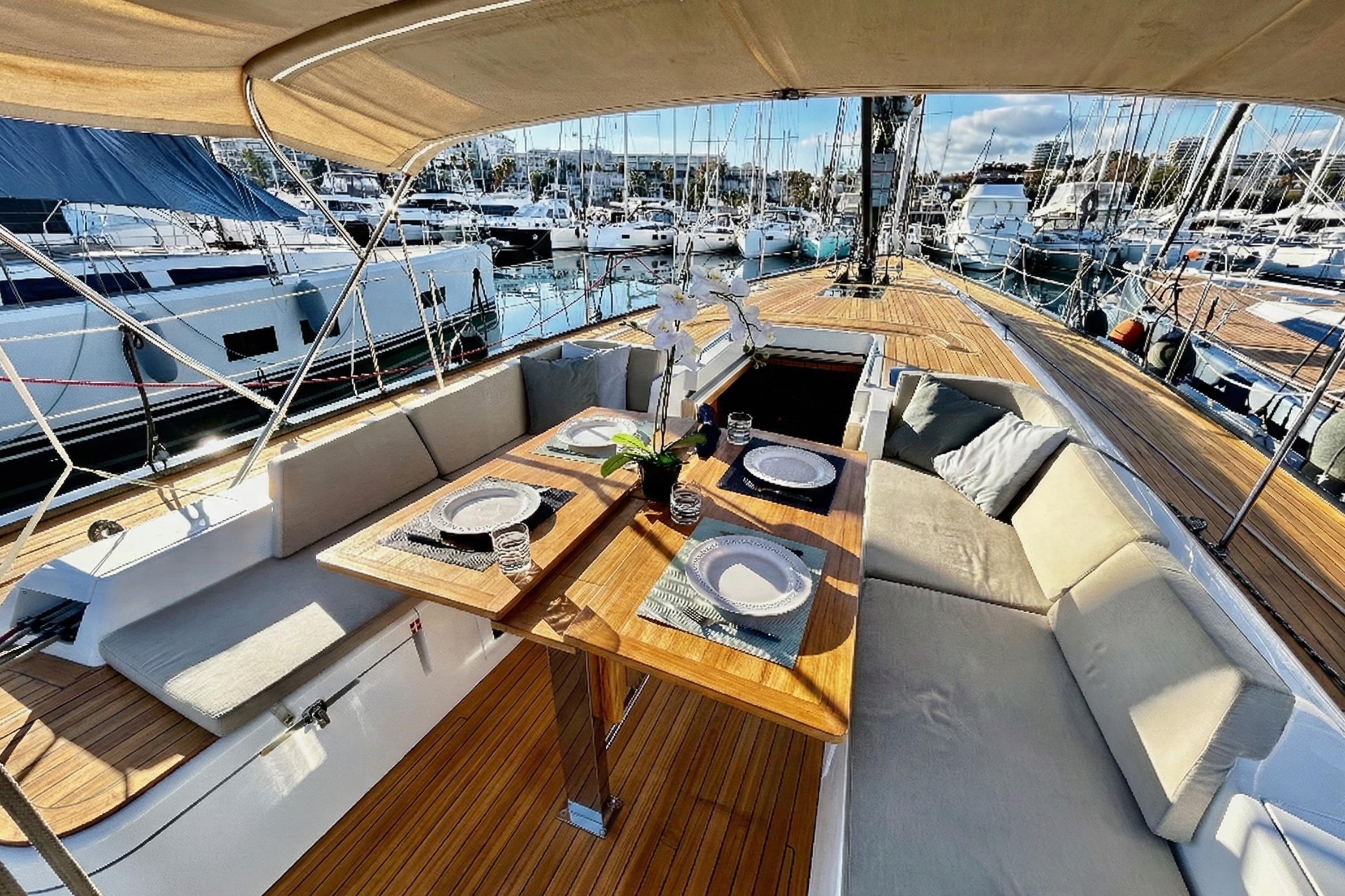 Luxurious 2022 Solaris 55 yacht with elegant outdoor dining area in marina setting.