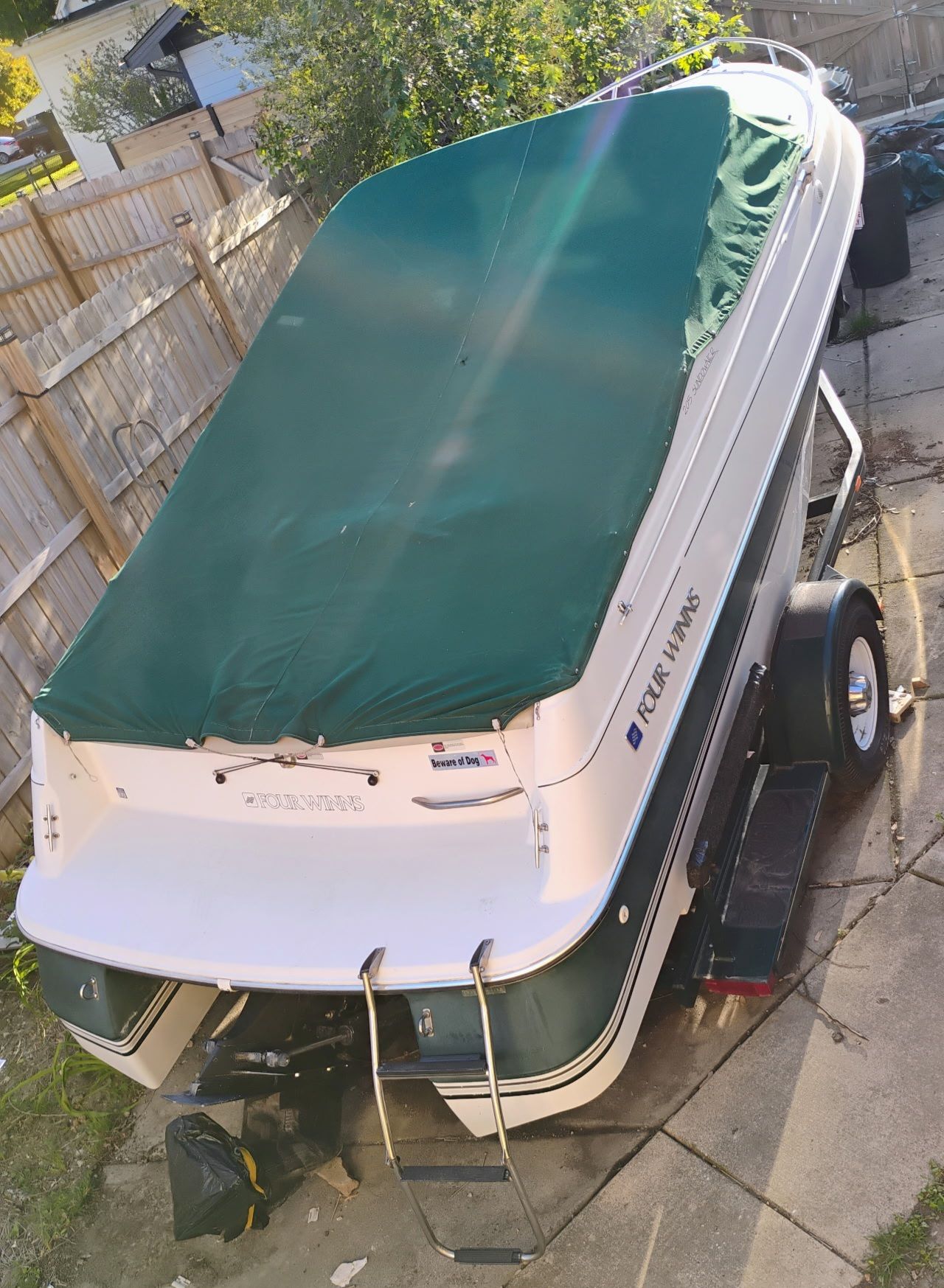 1995 Four Winns 205 Sundowner boat with green cover.