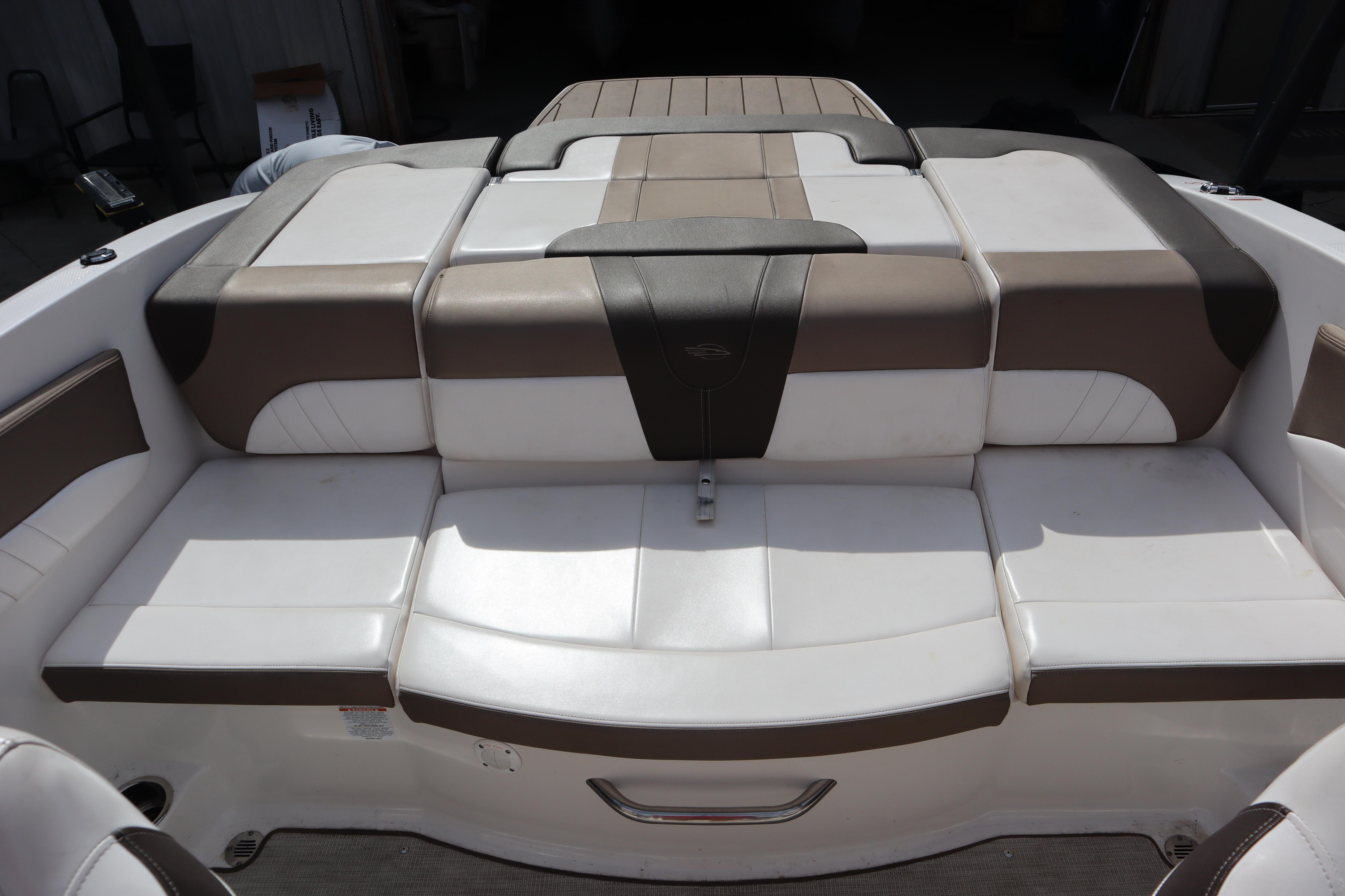 2021 Chaparral 21 SSi boat interior with cushioned seating in white and brown tones.