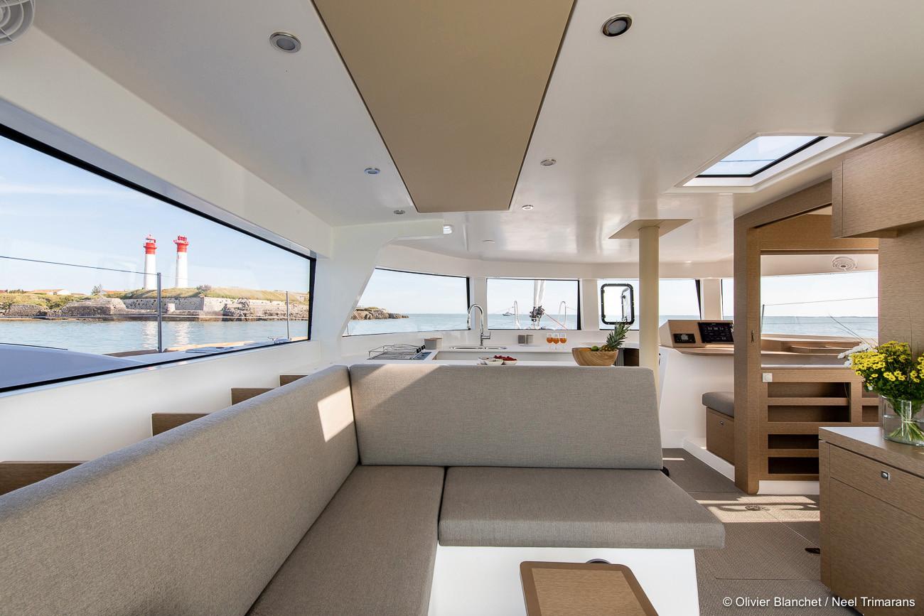 Modern interior of NEEL 47 trimaran, featuring spacious seating and panoramic windows, 2025 model.