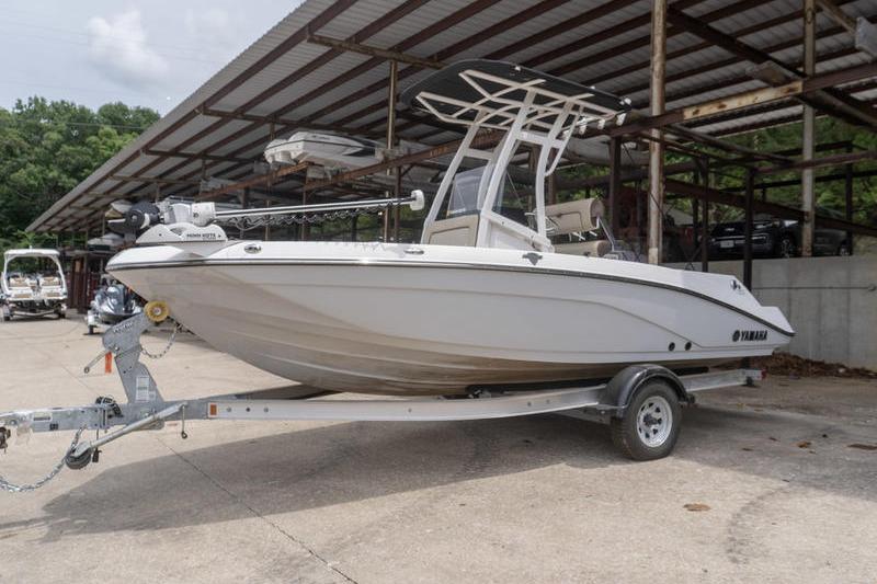 2023 Yamaha Boats 195 FSH Sport on trailer, parked under a metal canopy.