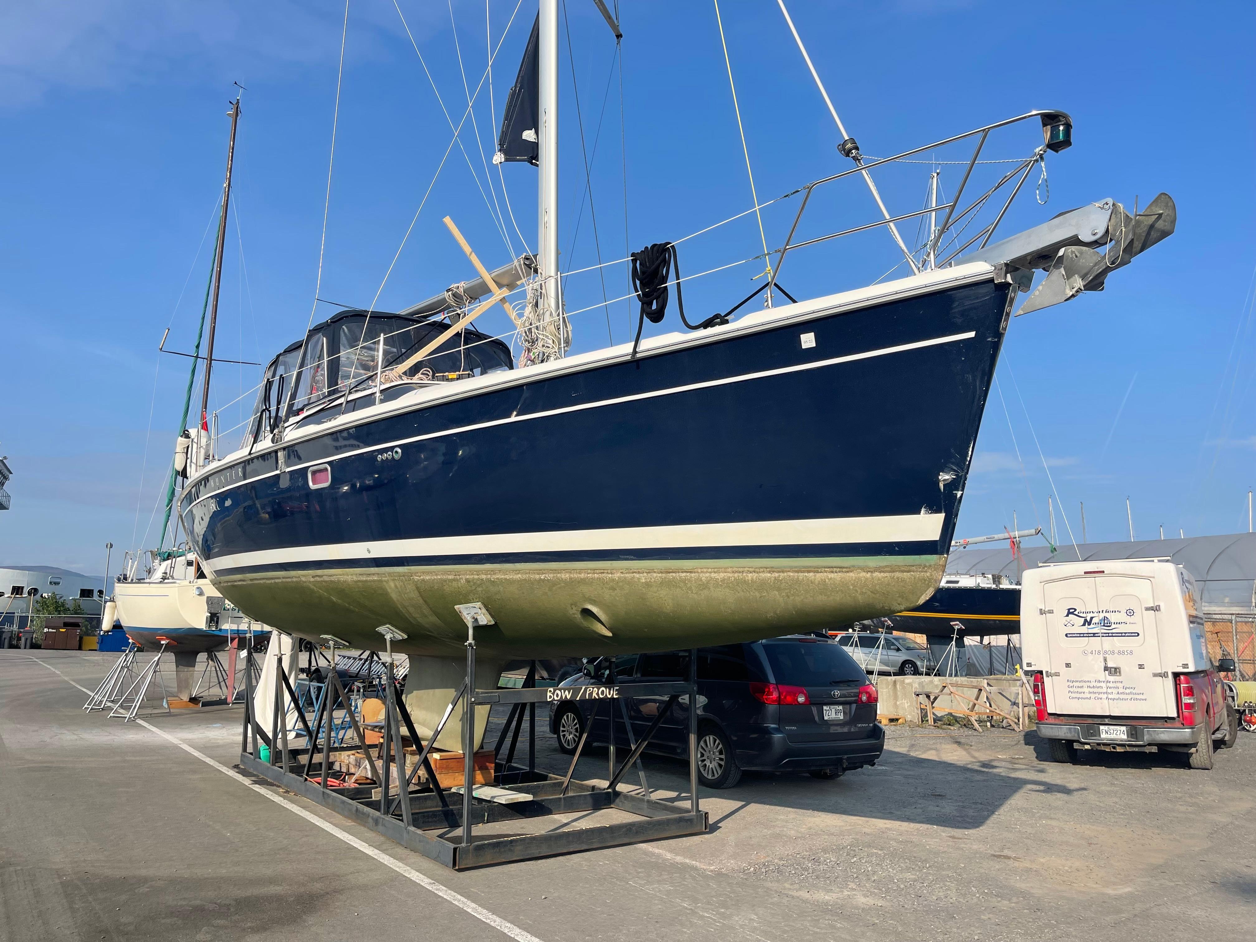 2006 Hunter 45cc sailboat on dry dock, blue hull, marina setting.