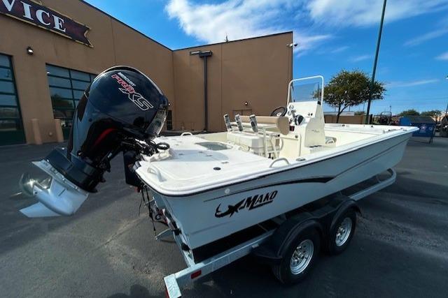2026 Mako Pro Skiff 19 CC boat on trailer, parked outside a service building.