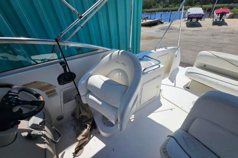 2001 Sea Ray 260 Sundancer boat interior with white seating and steering wheel.
