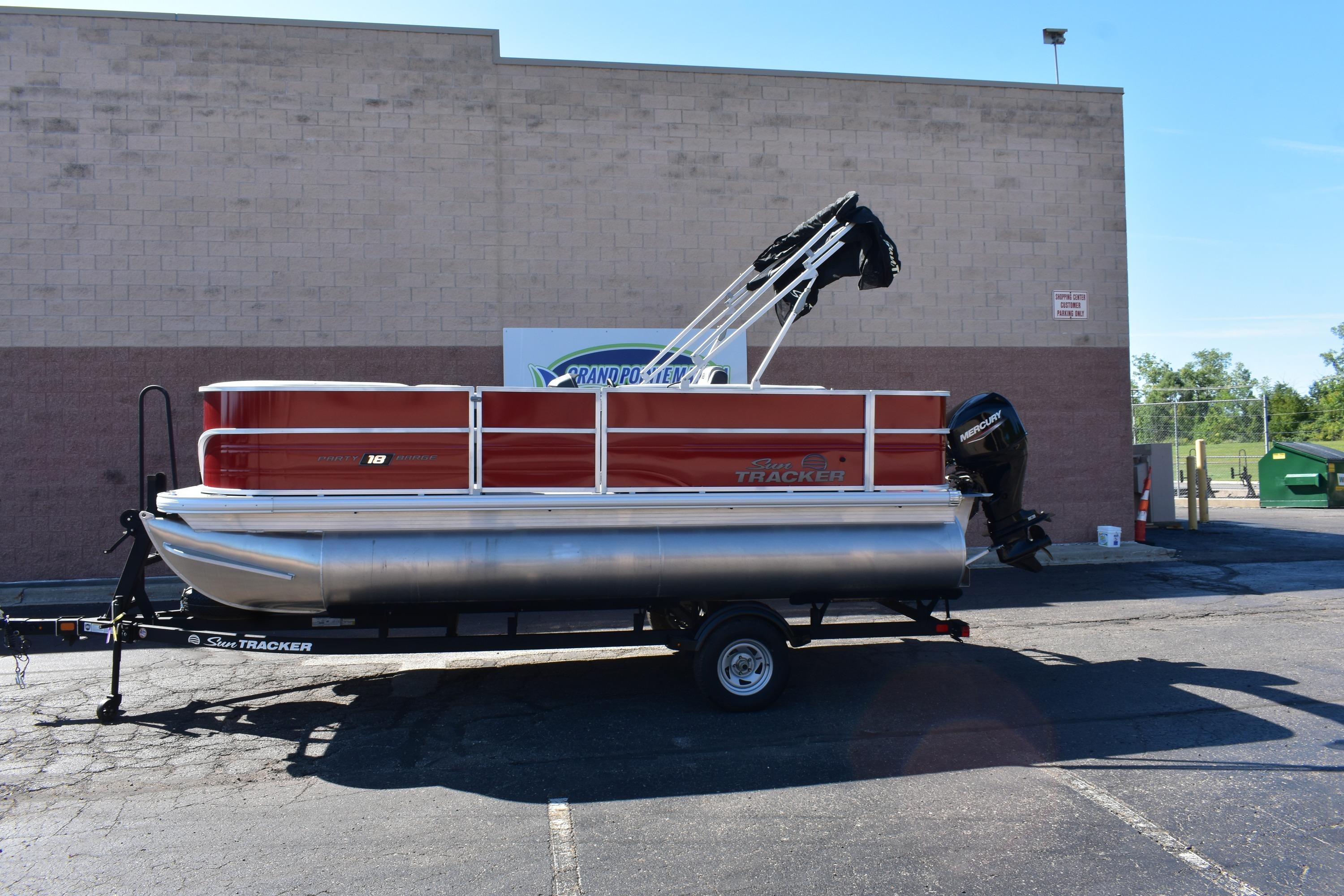 2026 Sun Tracker Party Barge 18 DLX pontoon boat on trailer, parked outdoors.